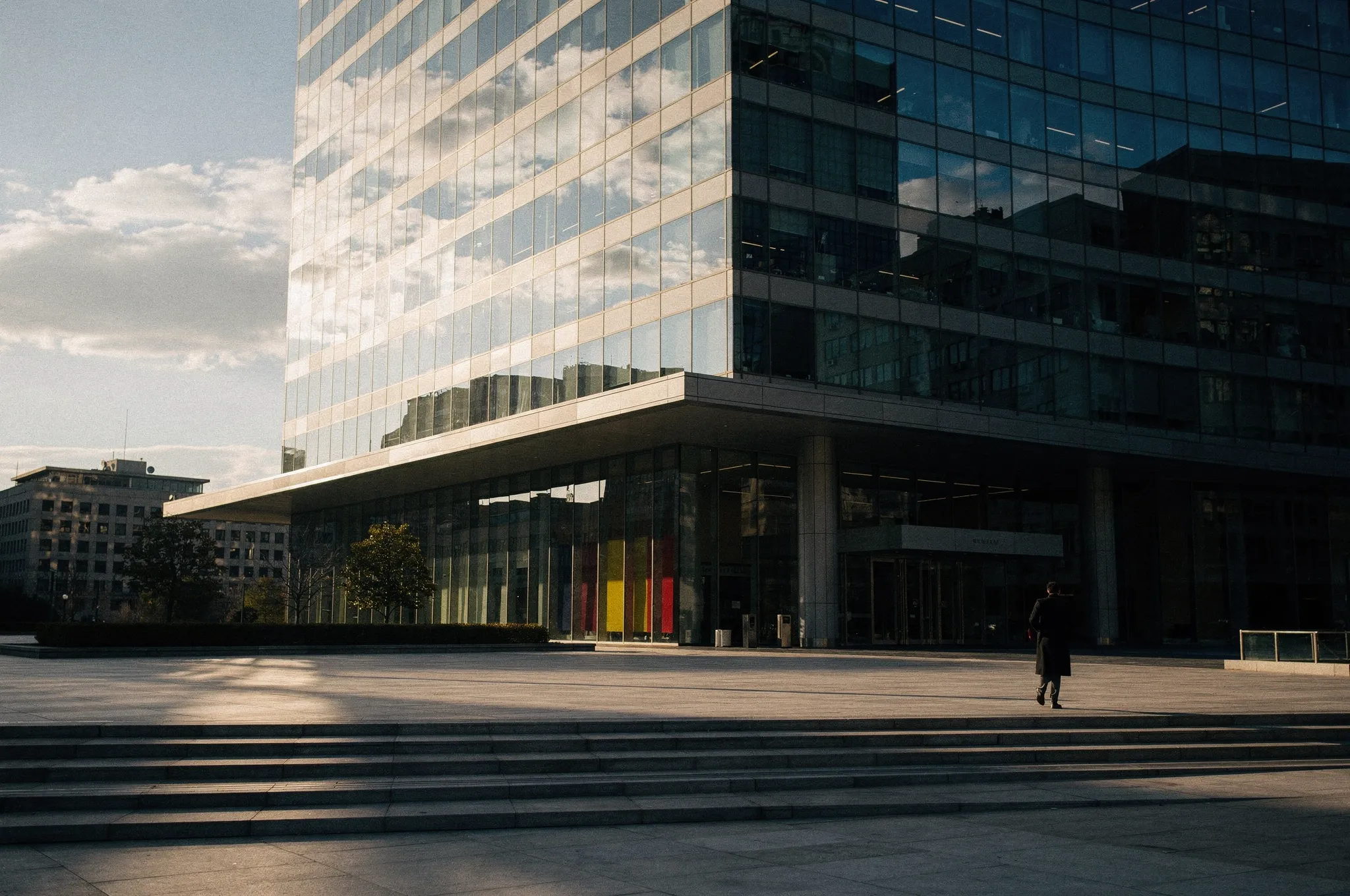 Modernes Bürogebäude mit Glasfassade und dramatischen Schatten in der Nachmittagssonne