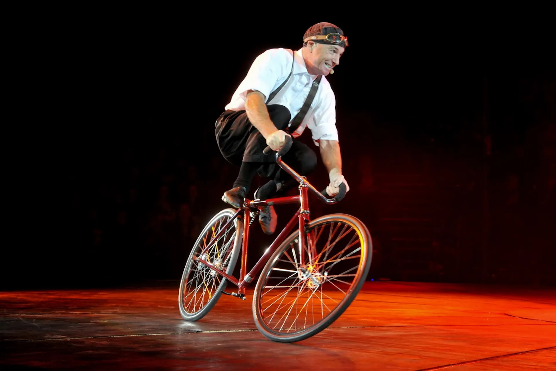 Zirkusartist balanciert auf Fahrrad – Momentaufnahme voller Spannung und Präzision.