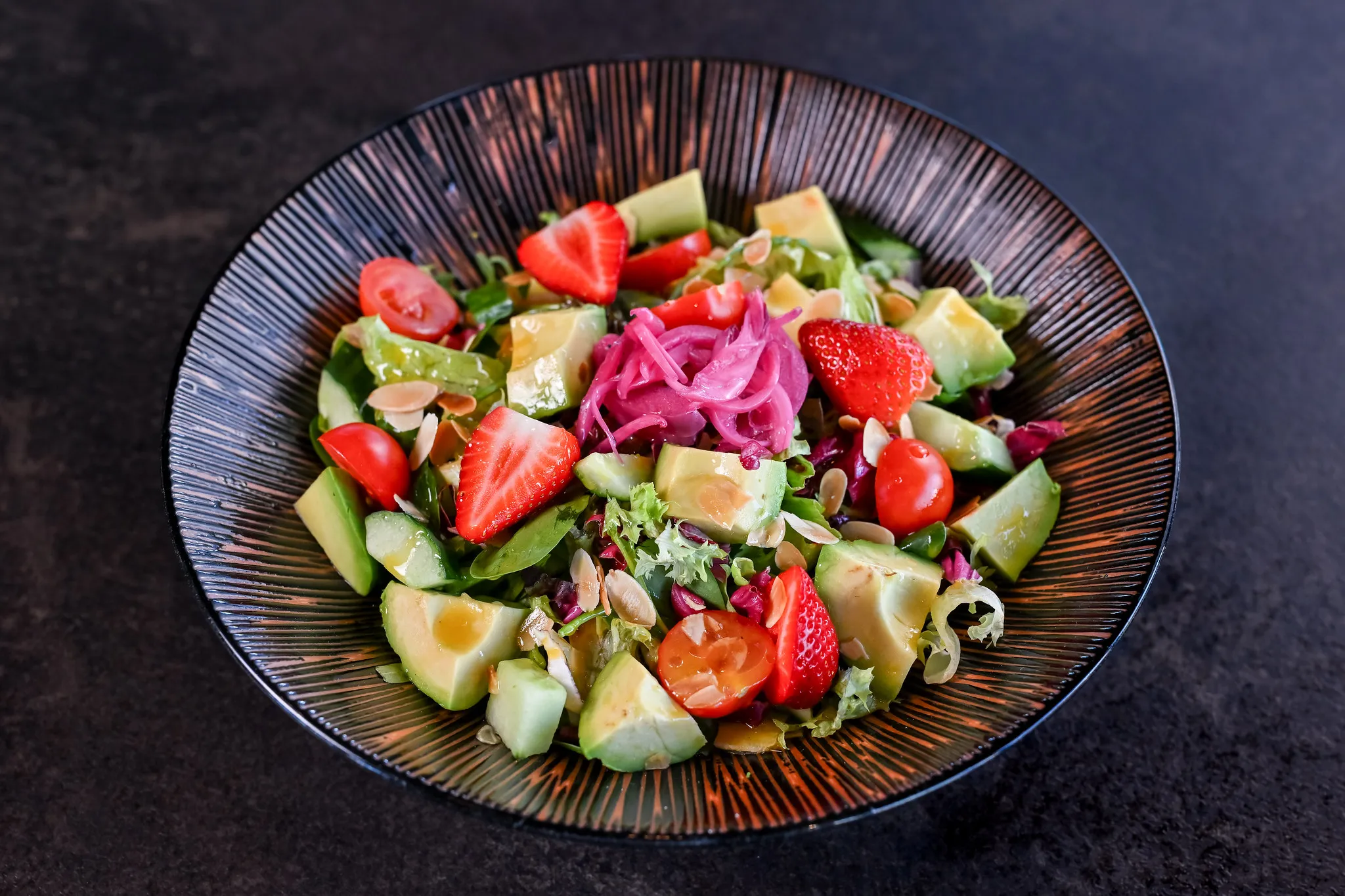 Frischer Avocadosalat mit Erdbeeren, Tomaten und Mandeln.