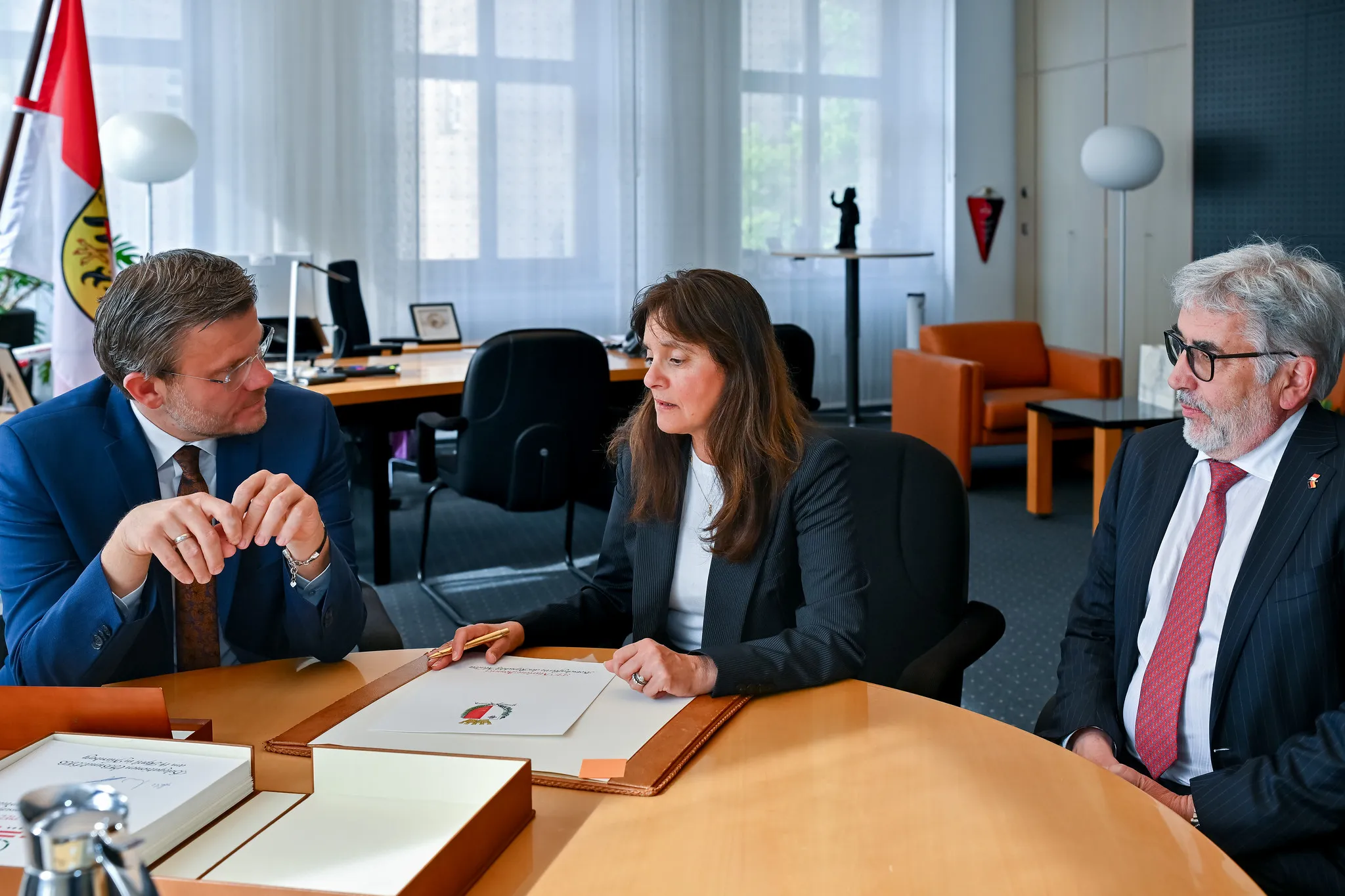 Drei Personen in Besprechung im Bürgermeisterbüro