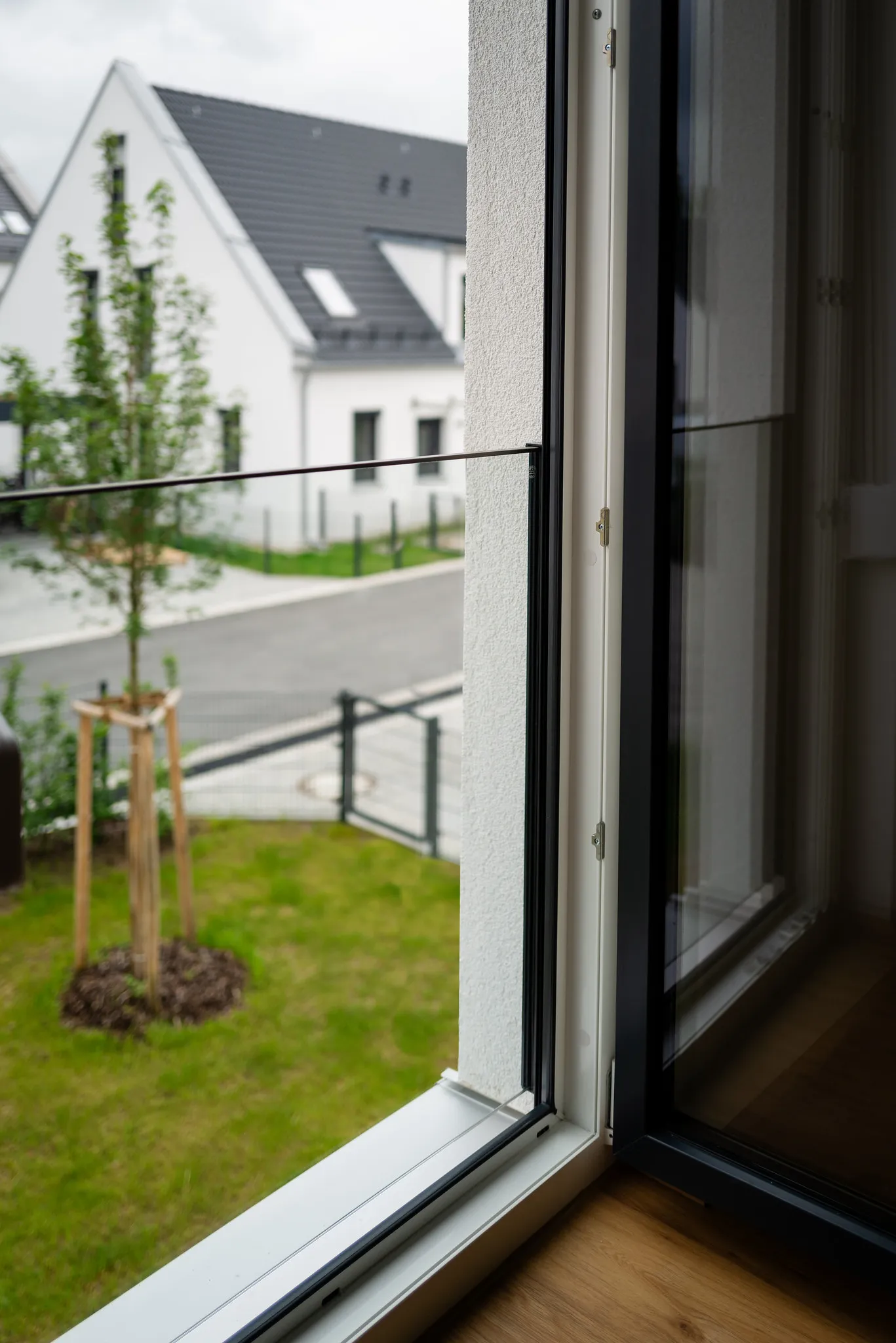 Bodentiefes Fenster mit Blick auf Neubau-Gärten.