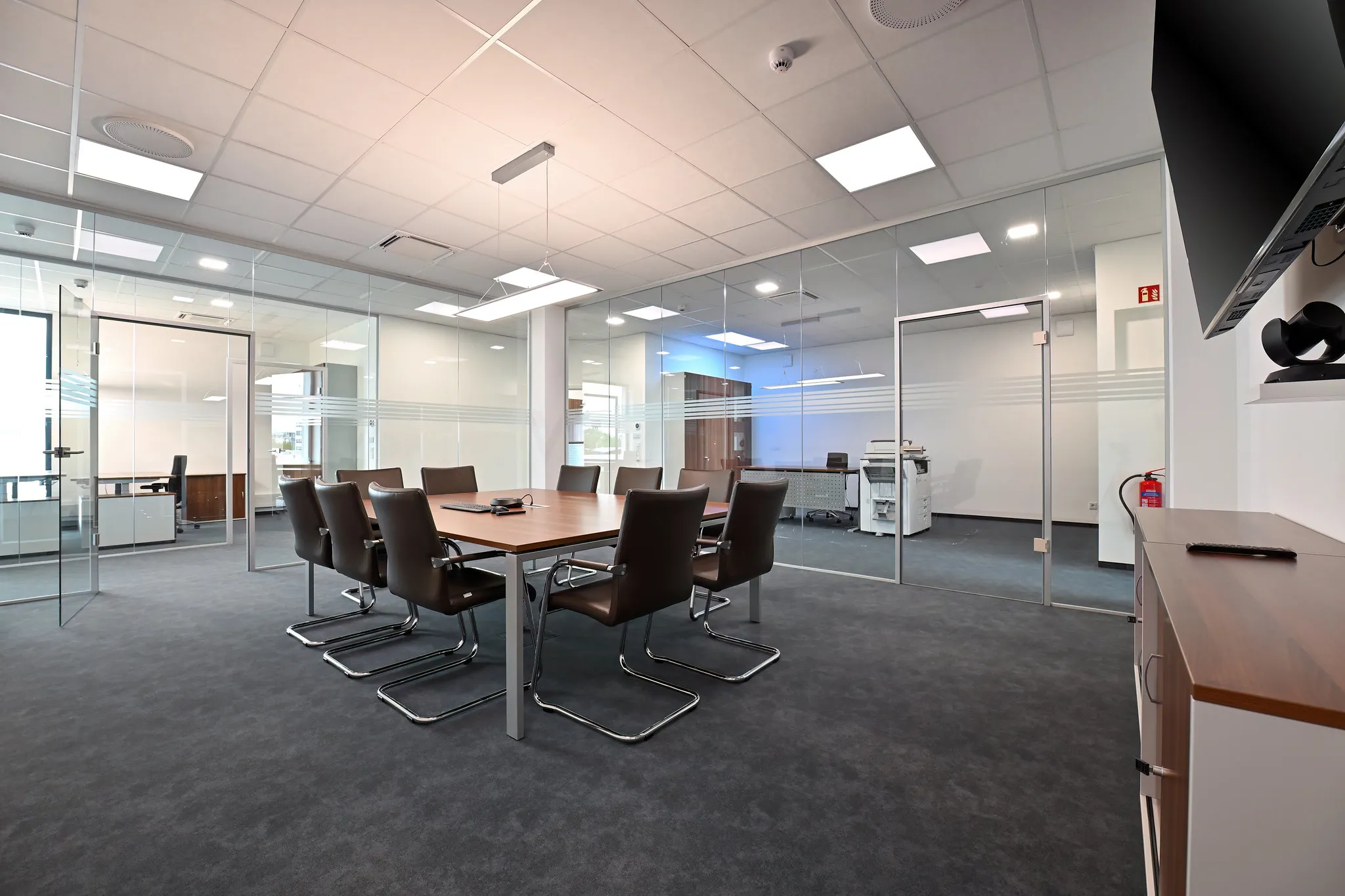 Büro-Konferenzraum mit Glaswänden und Besprechungstisch.