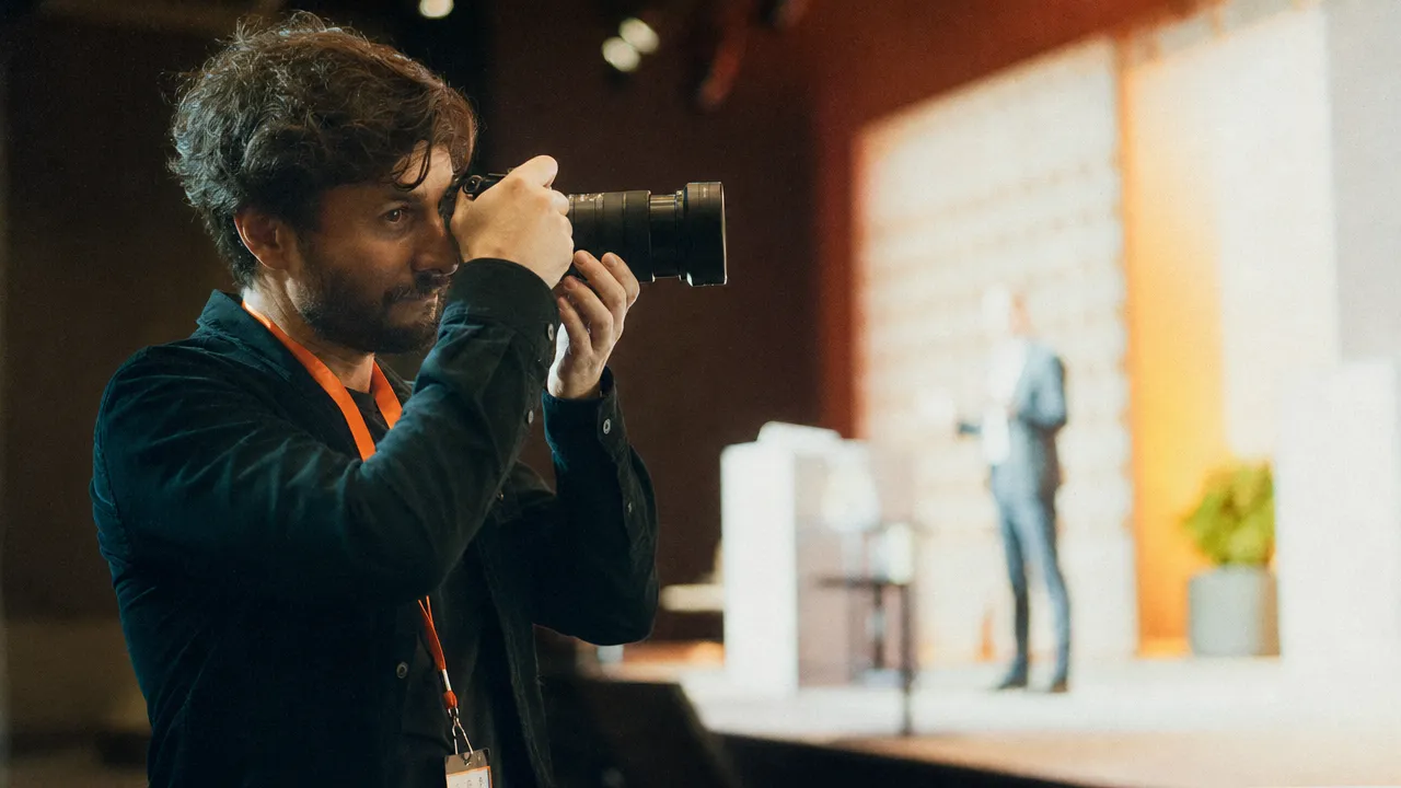 Fotograf erfasst einen Bühnenmoment mit markenkonformer Lichtstimmung auf einem Corporate Event