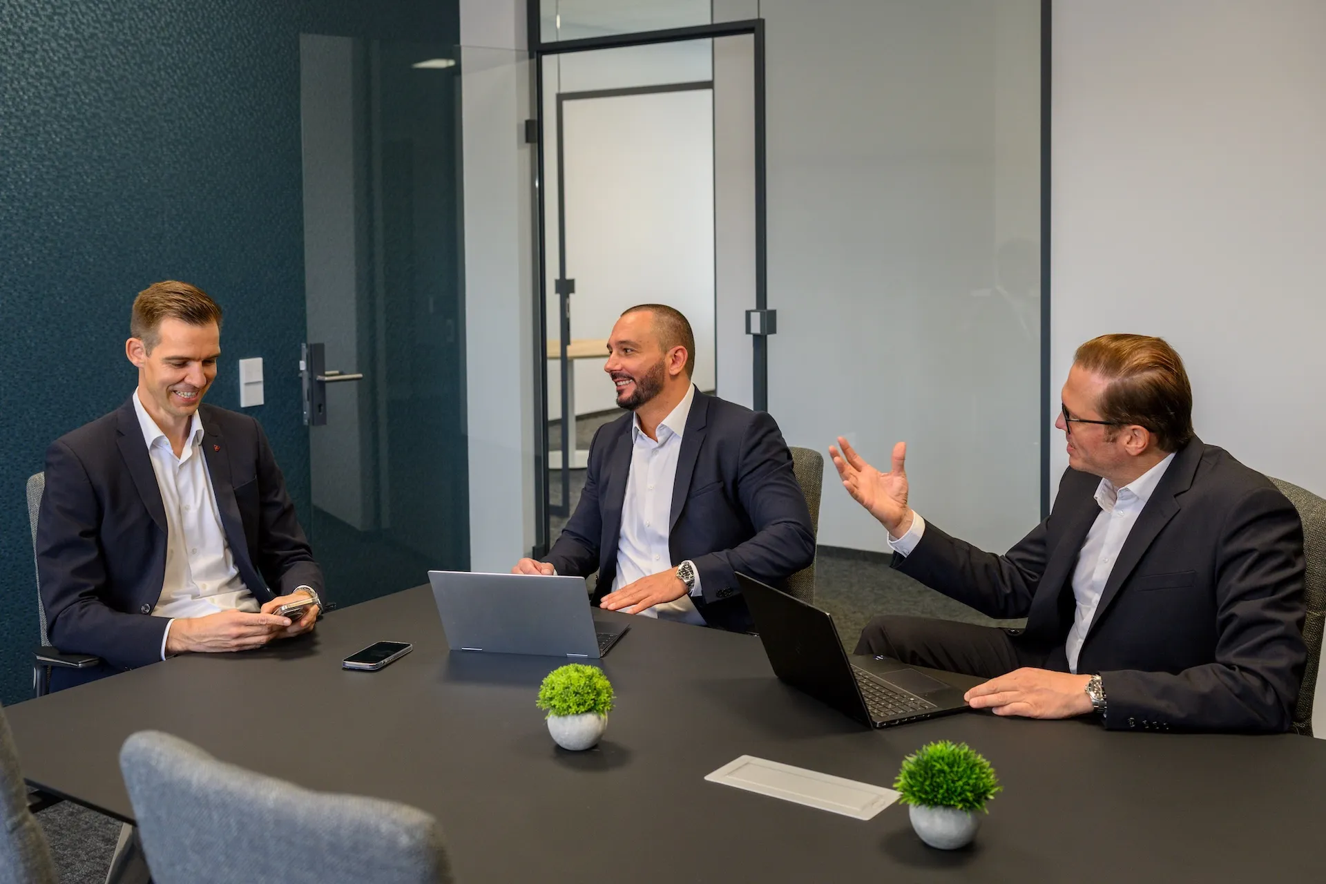 Drei Geschäftsleute im Besprechungsraum, Teamfoto mit Dynamik