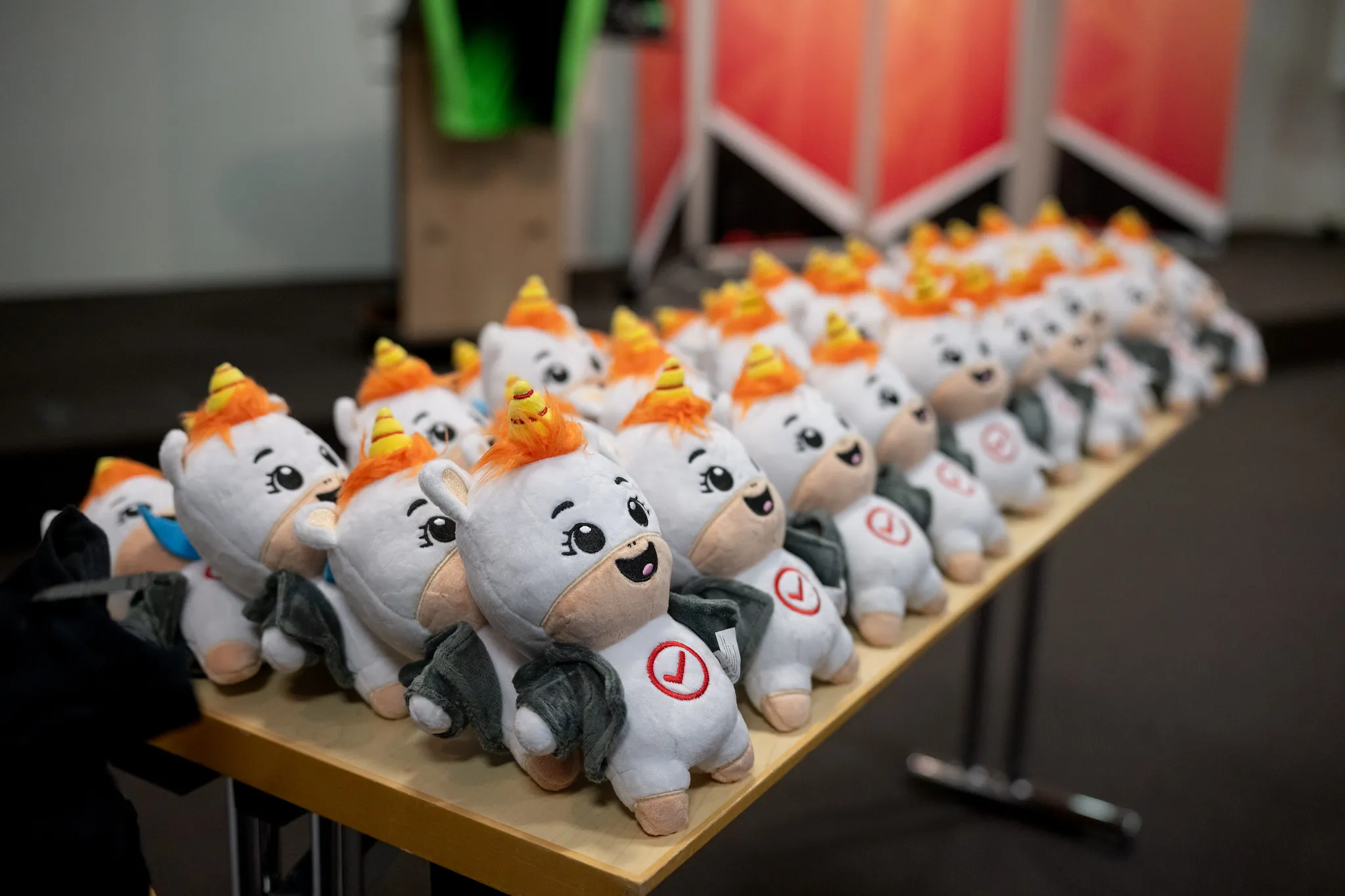 Reihe von Einhorn-Plüschfiguren als originelle Werbeartikel auf einem Messestand in Nürnberg.