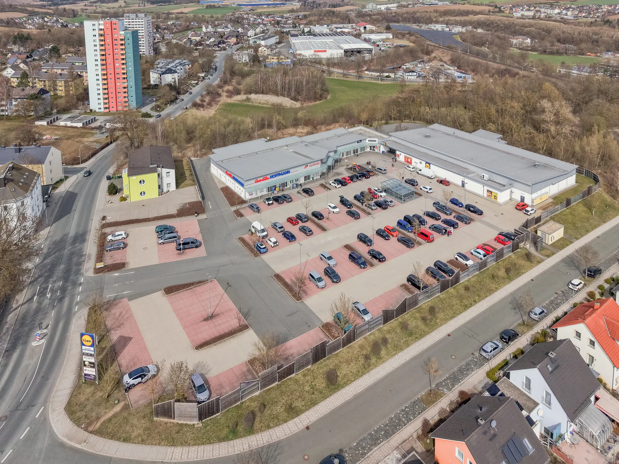 Drohnenaufnahme eines Einkaufszentrums mit Lidl und weiten Parkflächen