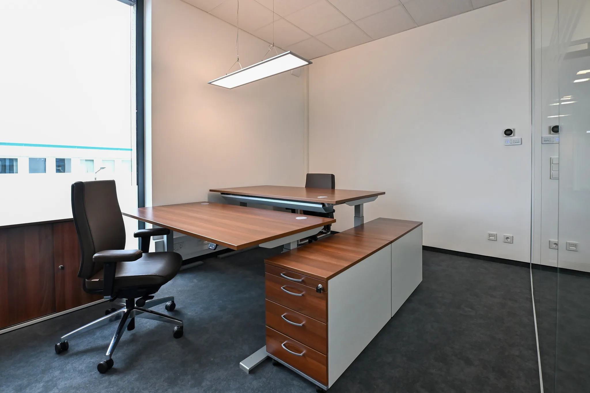 Einzelbüro mit höhenverstellbaren Schreibtischen.