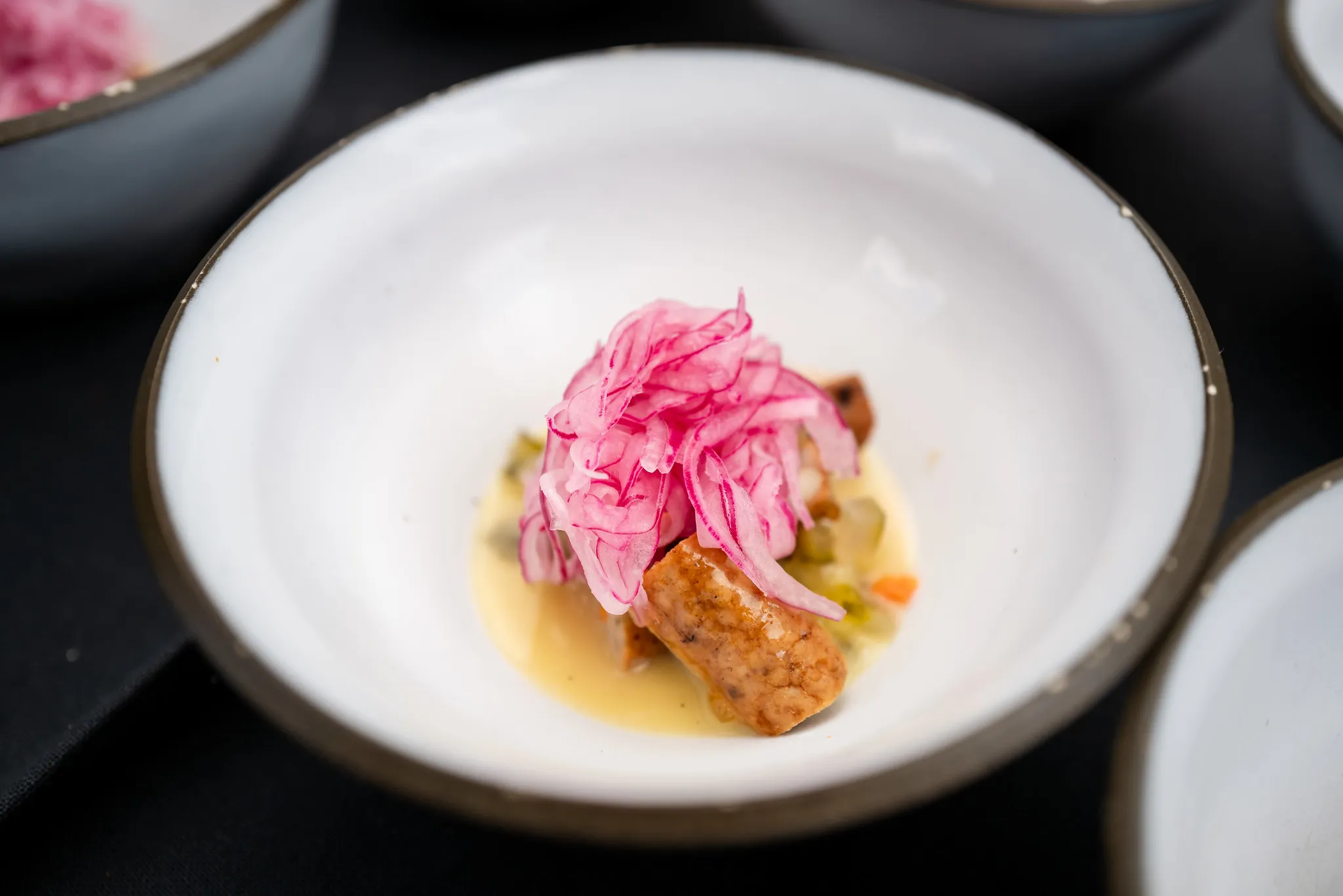 Fine-Dining-Gang mit eingelegten roten Zwiebeln, elegante Anrichte-Fotografie.