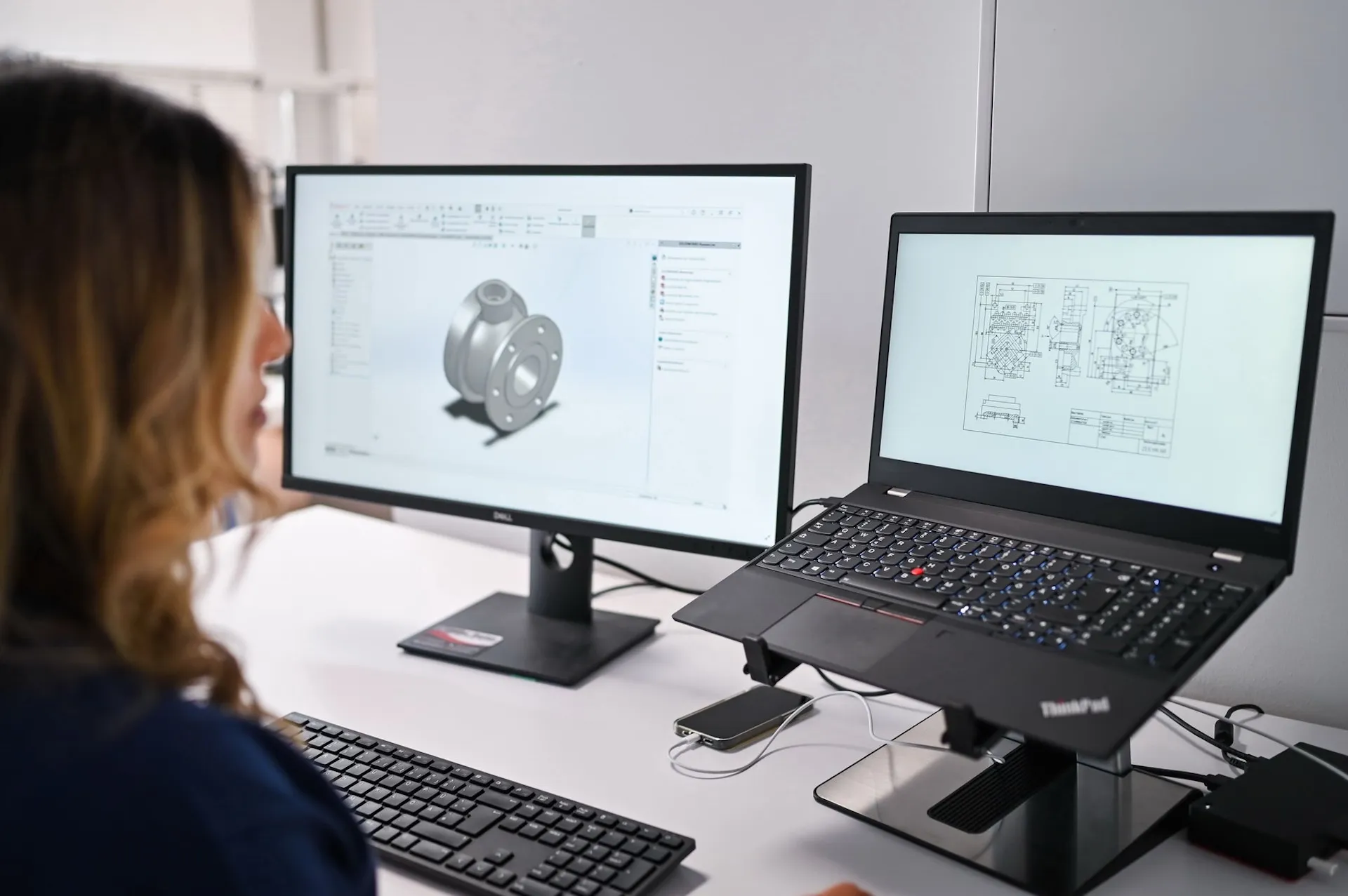 Mitarbeiterin arbeitet an CAD-Software, moderne Technik im Fokus der Unternehmensfotografie.