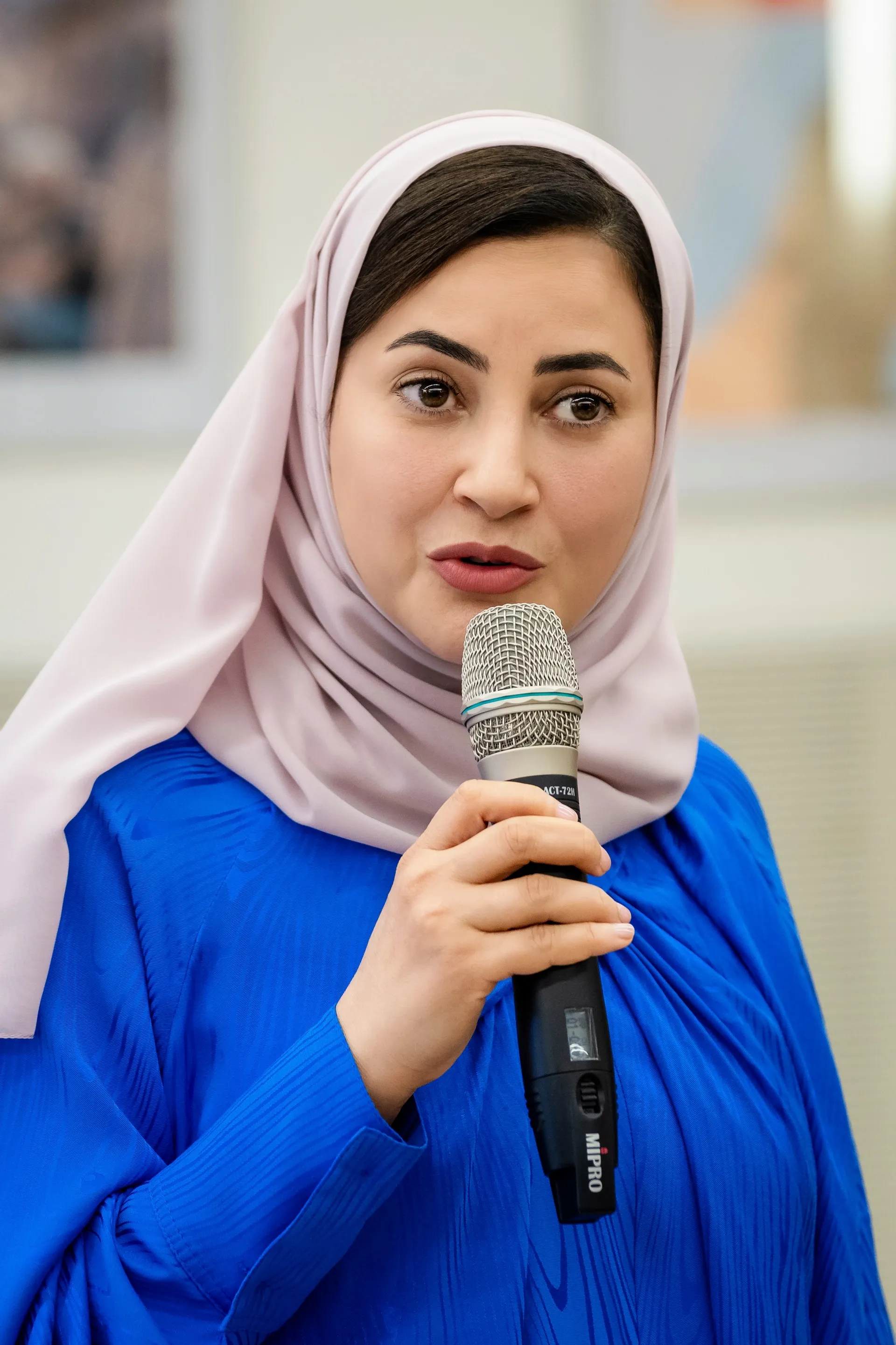 Frau mit Kopftuch spricht bei Firmenevent, starke Unternehmenskommunikation