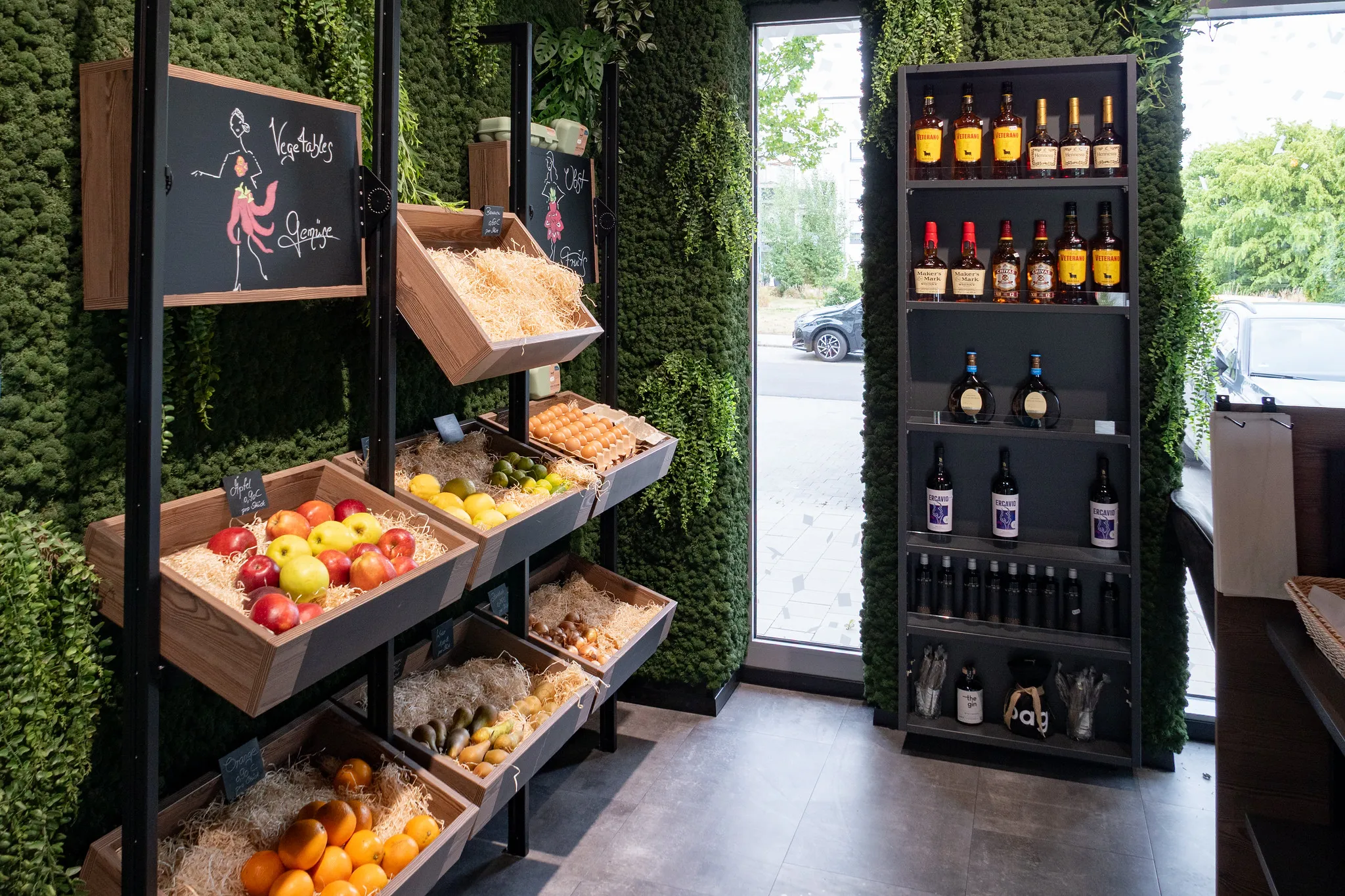 Frischetheke mit Obst und Spirituosenregal bei Ladeneröffnung