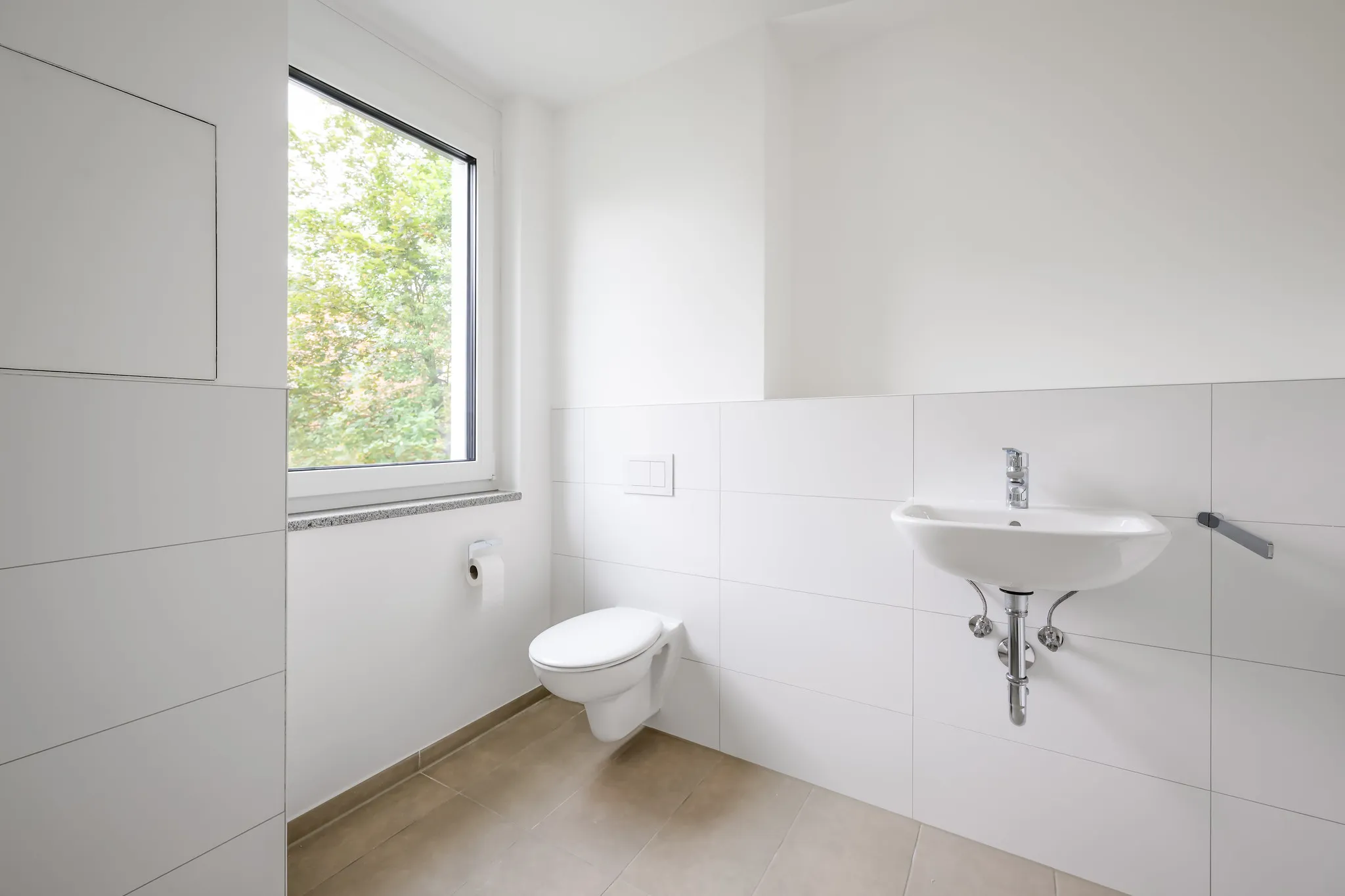 Gäste-WC mit Fenster, Waschbecken und Hänge-WC.