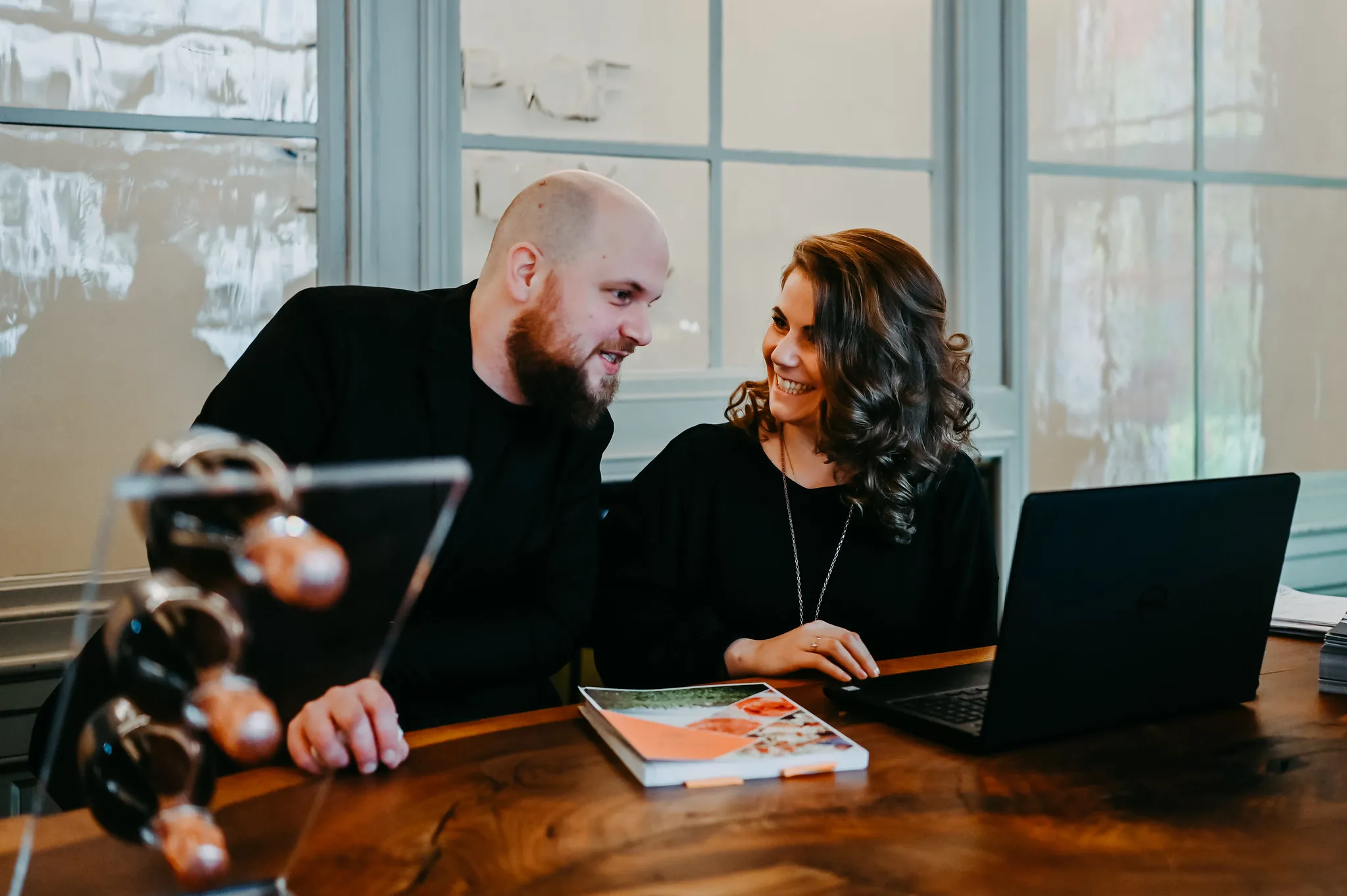 Gastronomenpaar im Planungsgespräch am Laptop, Unternehmensfotografie für die Gastronomie.