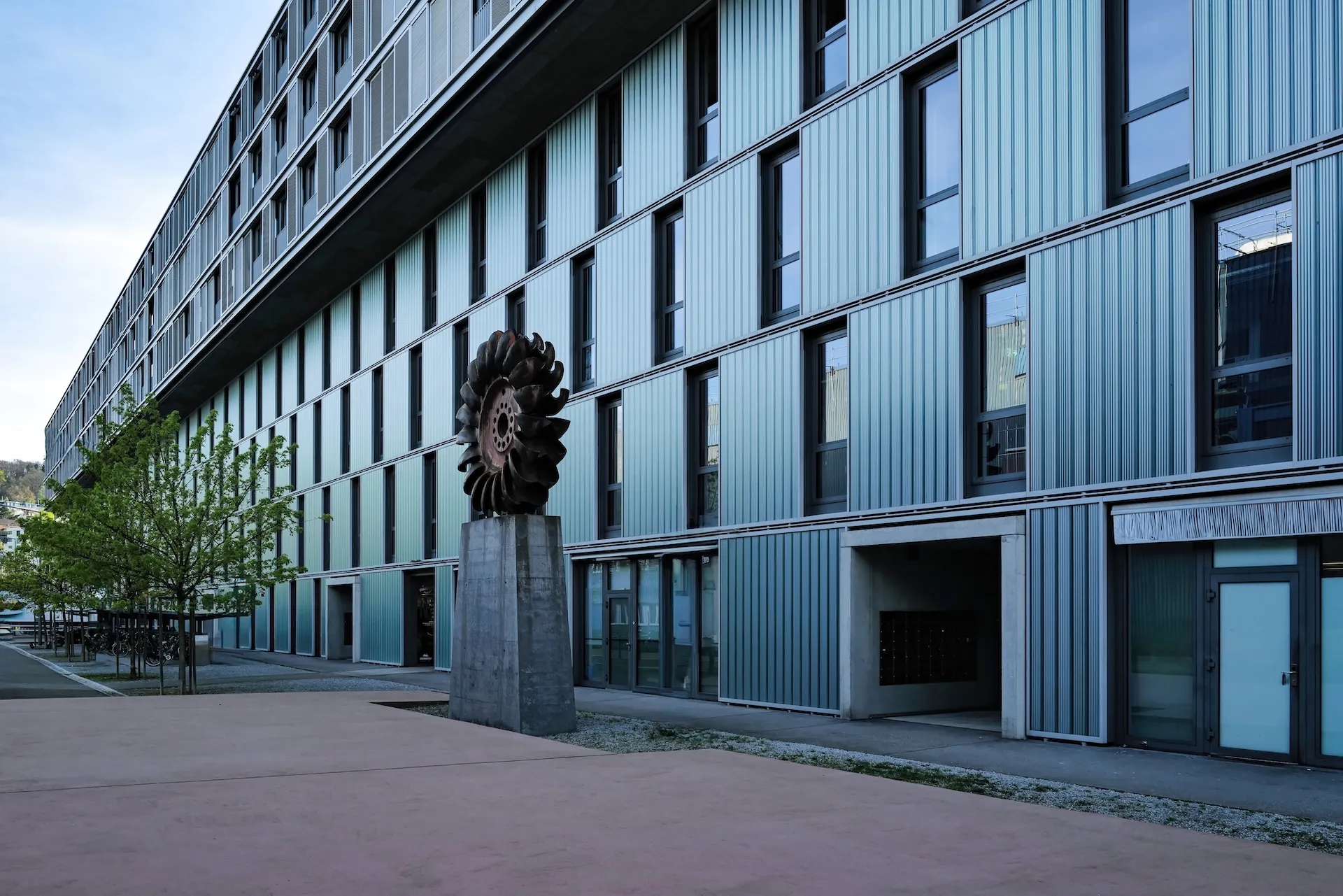 Fassade mit Turbinen-Skulptur, futuristisch.