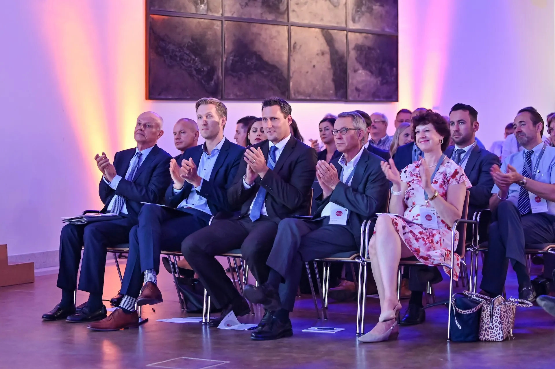 Zuhörende Geschäftsleute bei einer Konferenz, eingefangen mit professioneller Eventreportage.