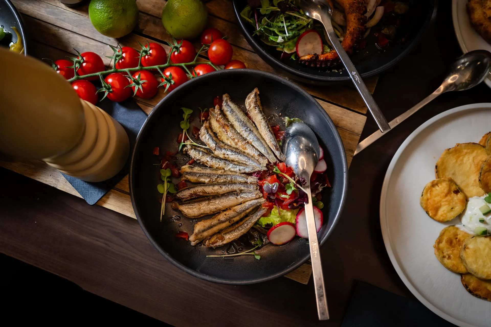 Griechische Vorspeisen mit Fisch und Salat, dekorativ angerichtet – frische Meeresküche.