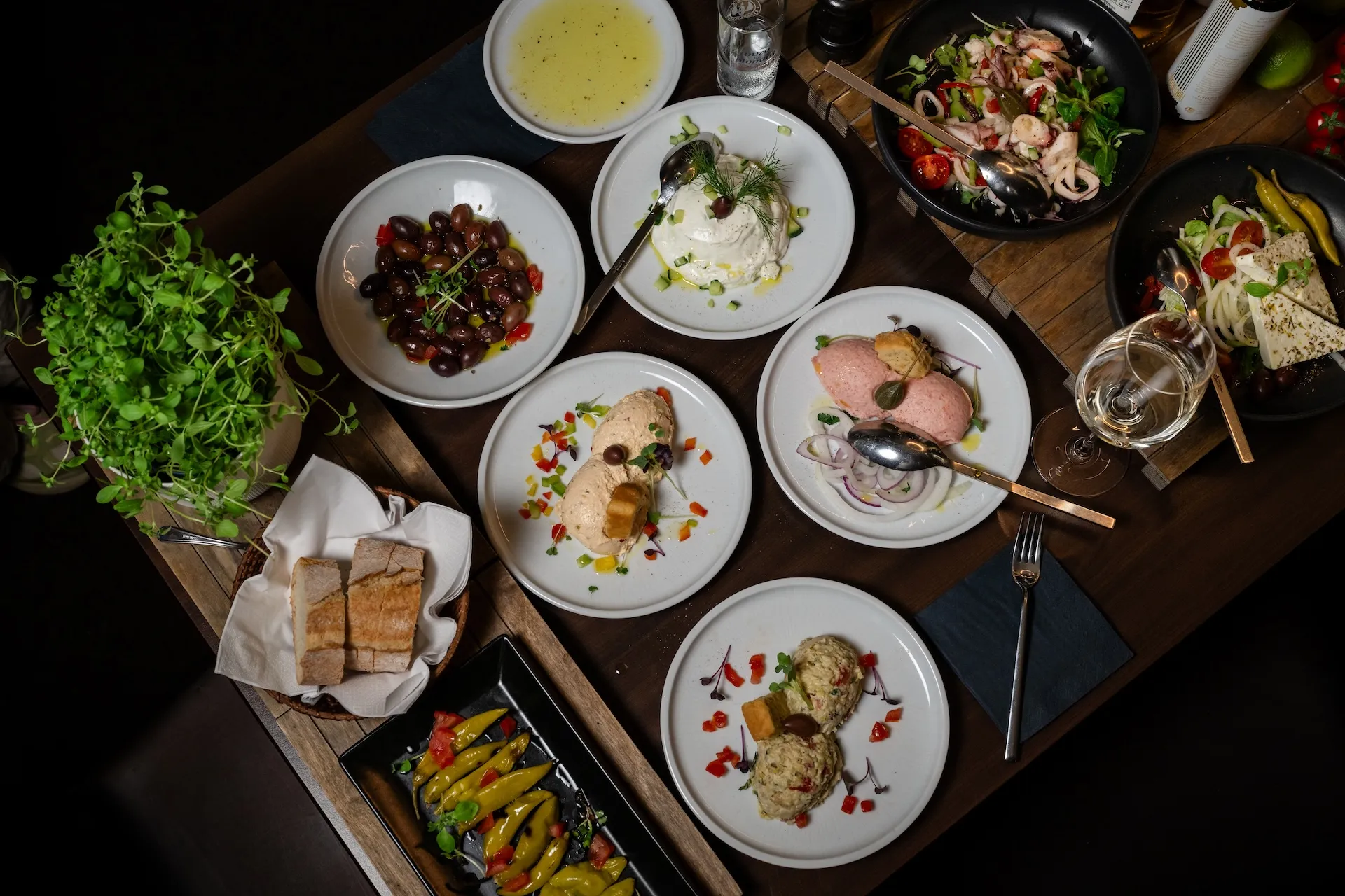Griechische Vorspeisen mit verschiedenen Aufstrichen, Brot, Ouzo und Wein – authentische Taverna-Atmosphäre.
