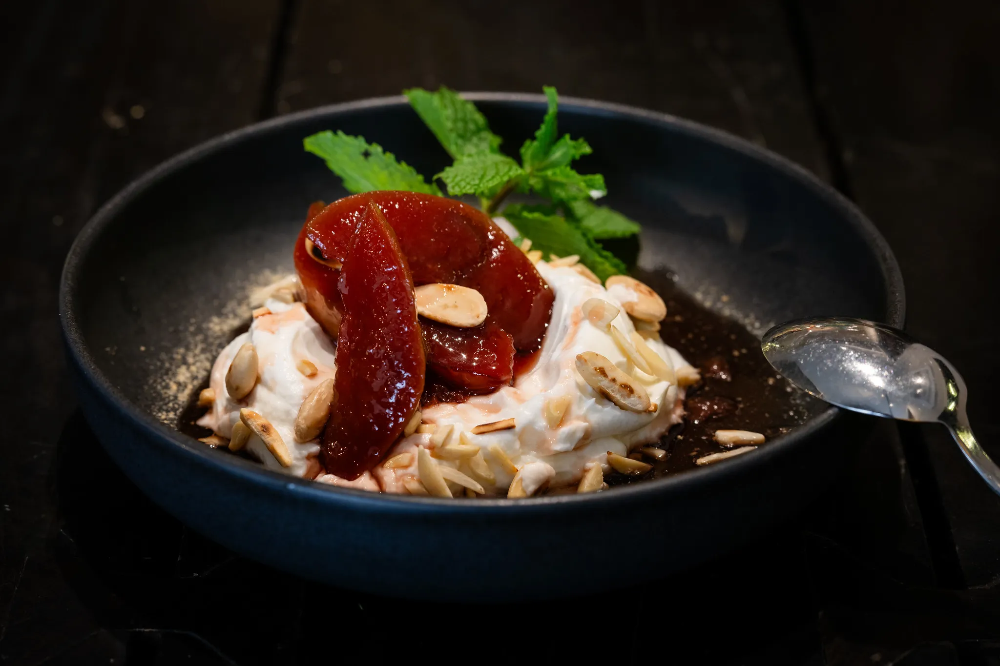 Griechisches Dessert mit Joghurtcreme, Quittenkonfitüre und gerösteten Mandeln.