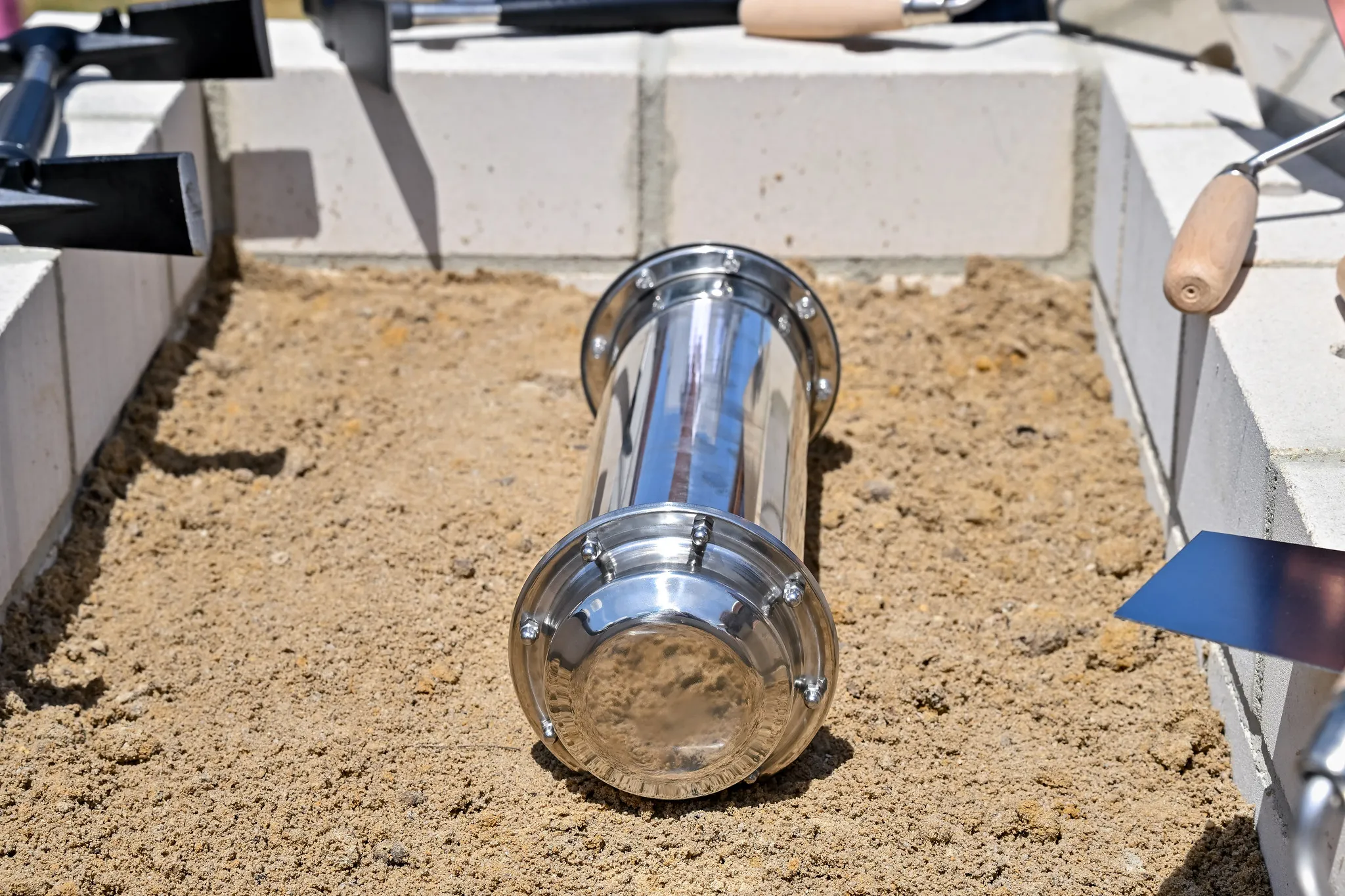 Edelstahl-Grundsteinkapsel in Sandform, Baustellenfotografie Grundsteinlegung