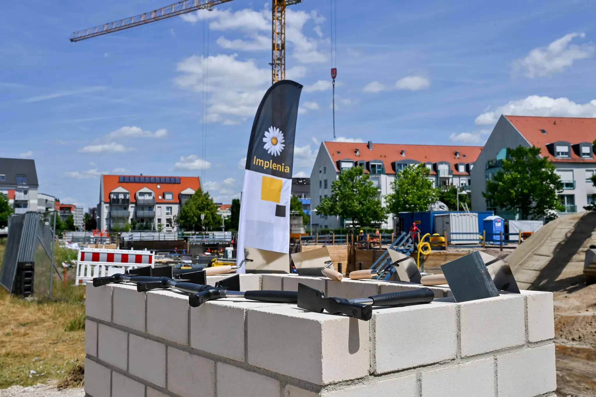 Maurerkellen und Werkzeuge auf Betonstein bei der Grundsteinlegung