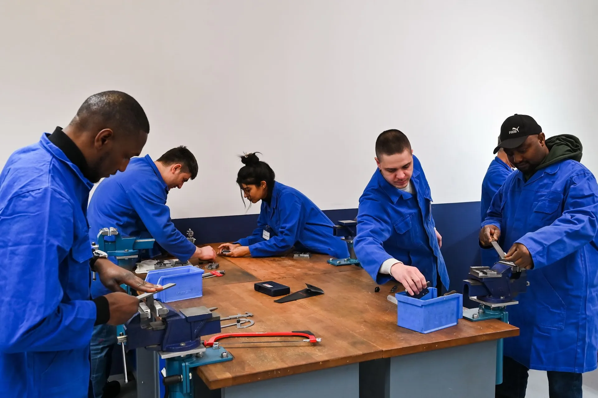 Auszubildende an der Werkbank, Teamarbeit und Nachwuchsförderung im Fokus.