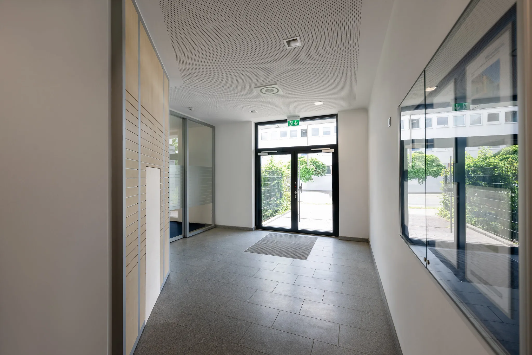 Hauseingang-Foyer mit Briefkastenanlage und Glastür.