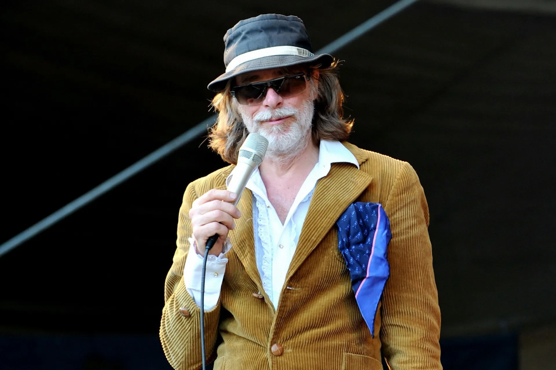 Helge Schneider mit Hut und Sonnenbrille auf der Bühne, charismatisch eingefangen durch die Kulturfotografie.