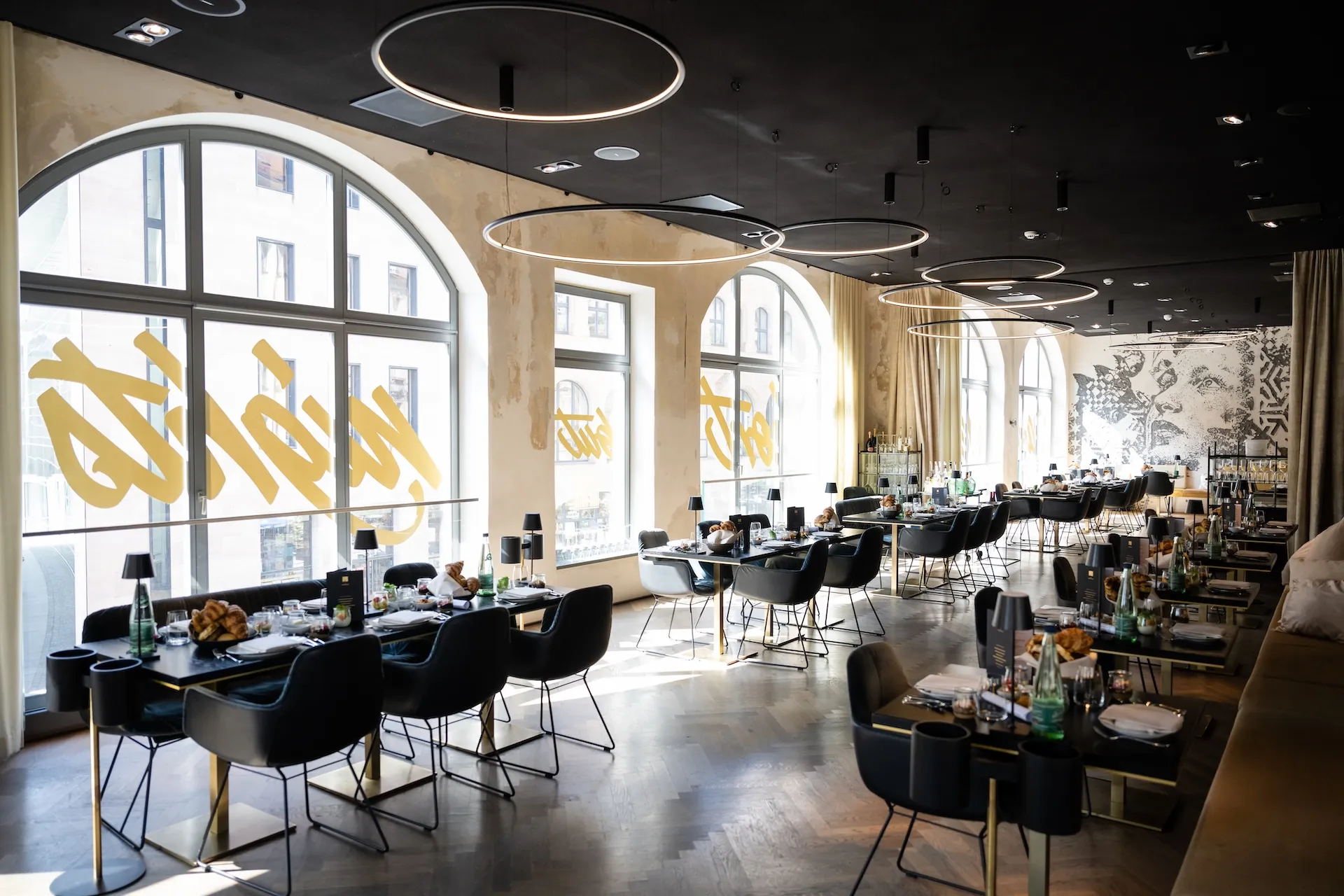 Helles Restaurant mit großer Fensterfront – lichtdurchflutete Gastronomie.