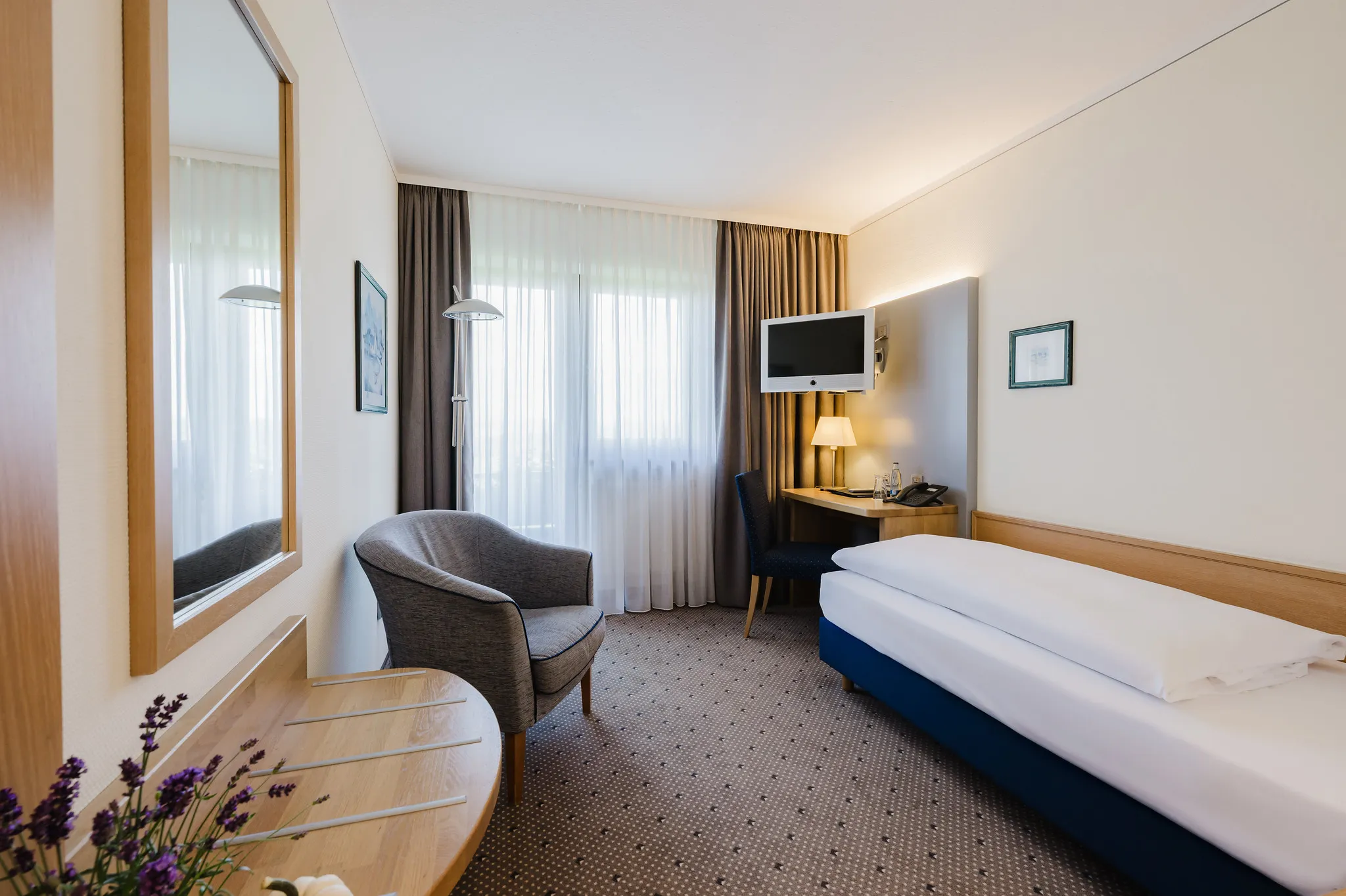 Klassisches Hotel-Einzelzimmer mit Lavendel-Dekoration und warmem Ambiente