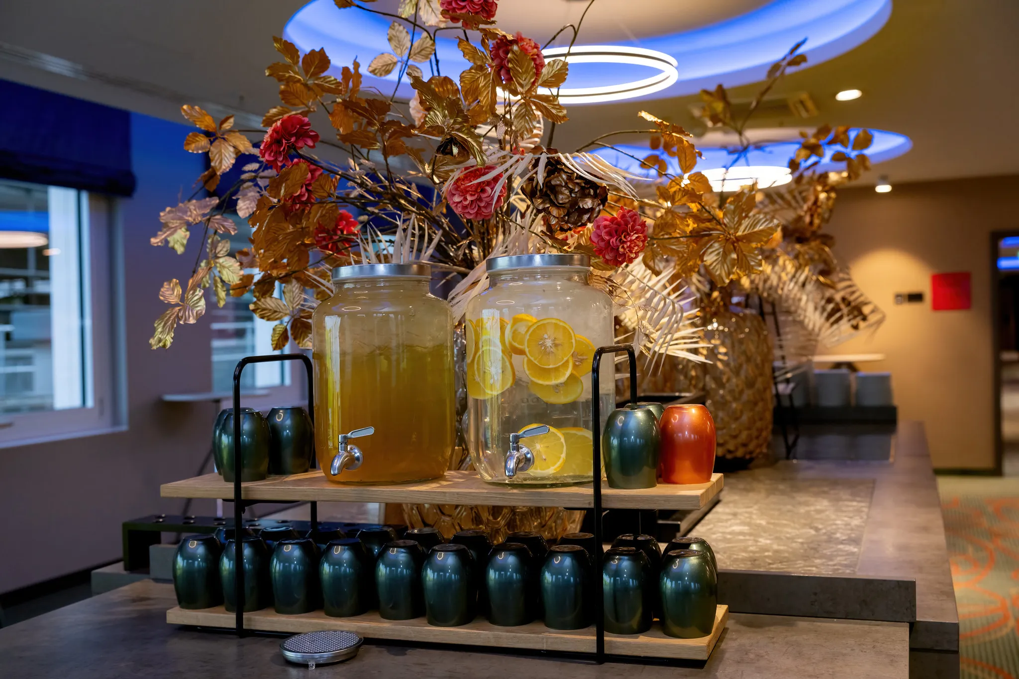 Stilvolle Hotel-Getränkestation mit Fruchtgetränke-Spendern und dekorativen goldenen Blättern