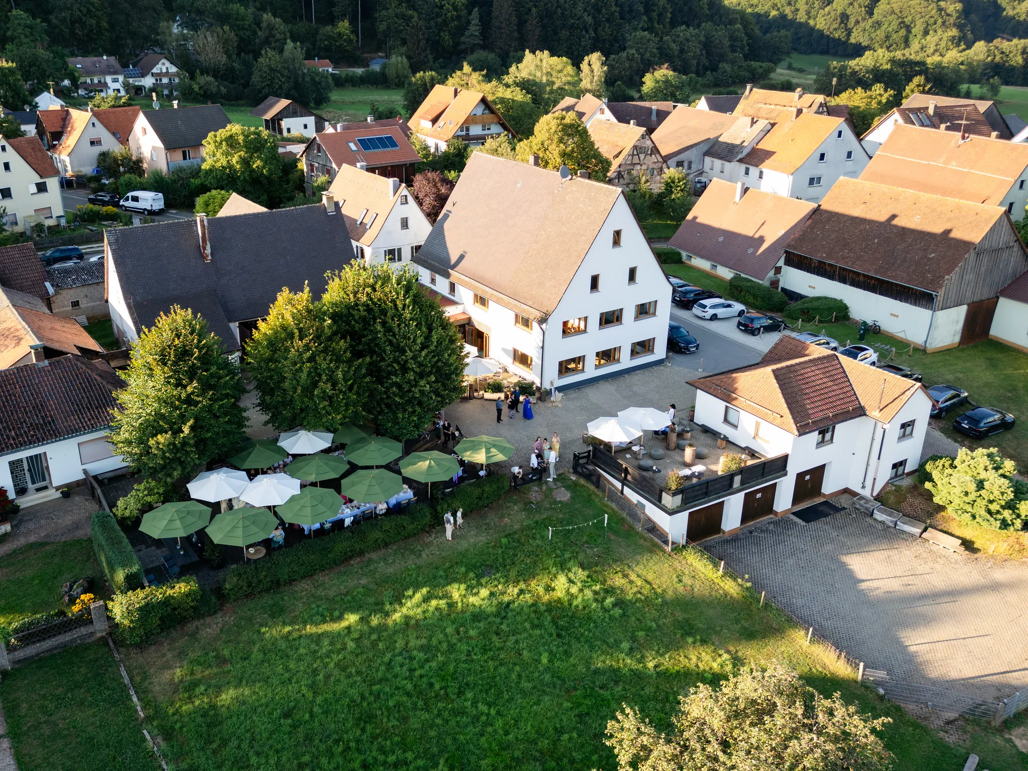 Luftaufnahme eines historischen Hotels mit Gartenterrasse aus der Vogelperspektive