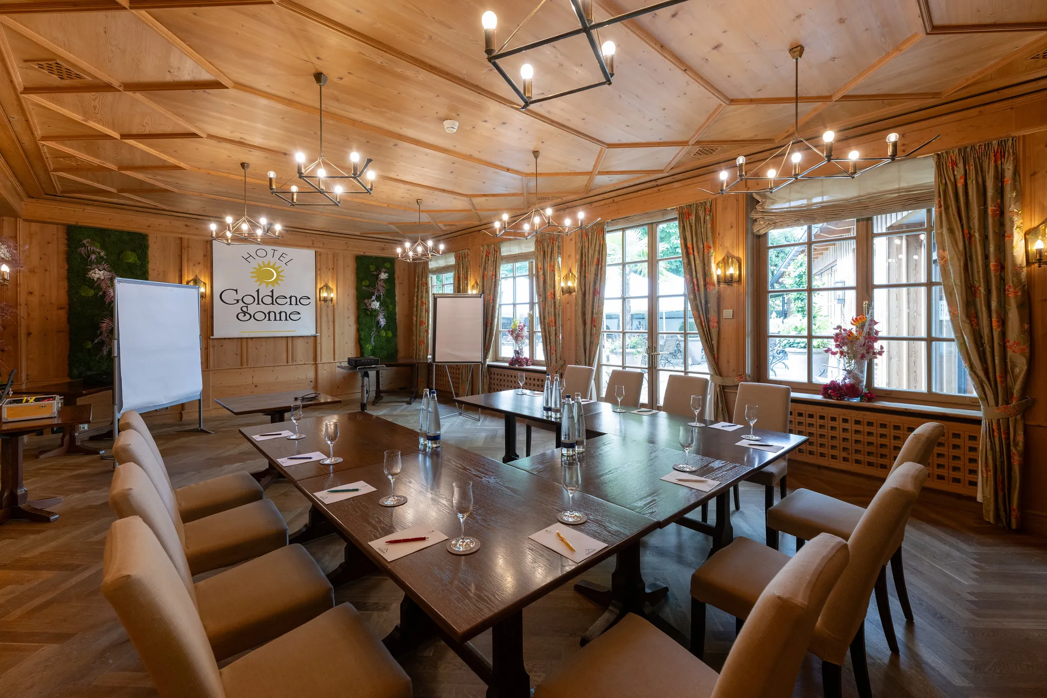 Hotelkonferenzraum mit warmer Holzvertäfelung und U-förmiger Bestuhlung für Tagungen