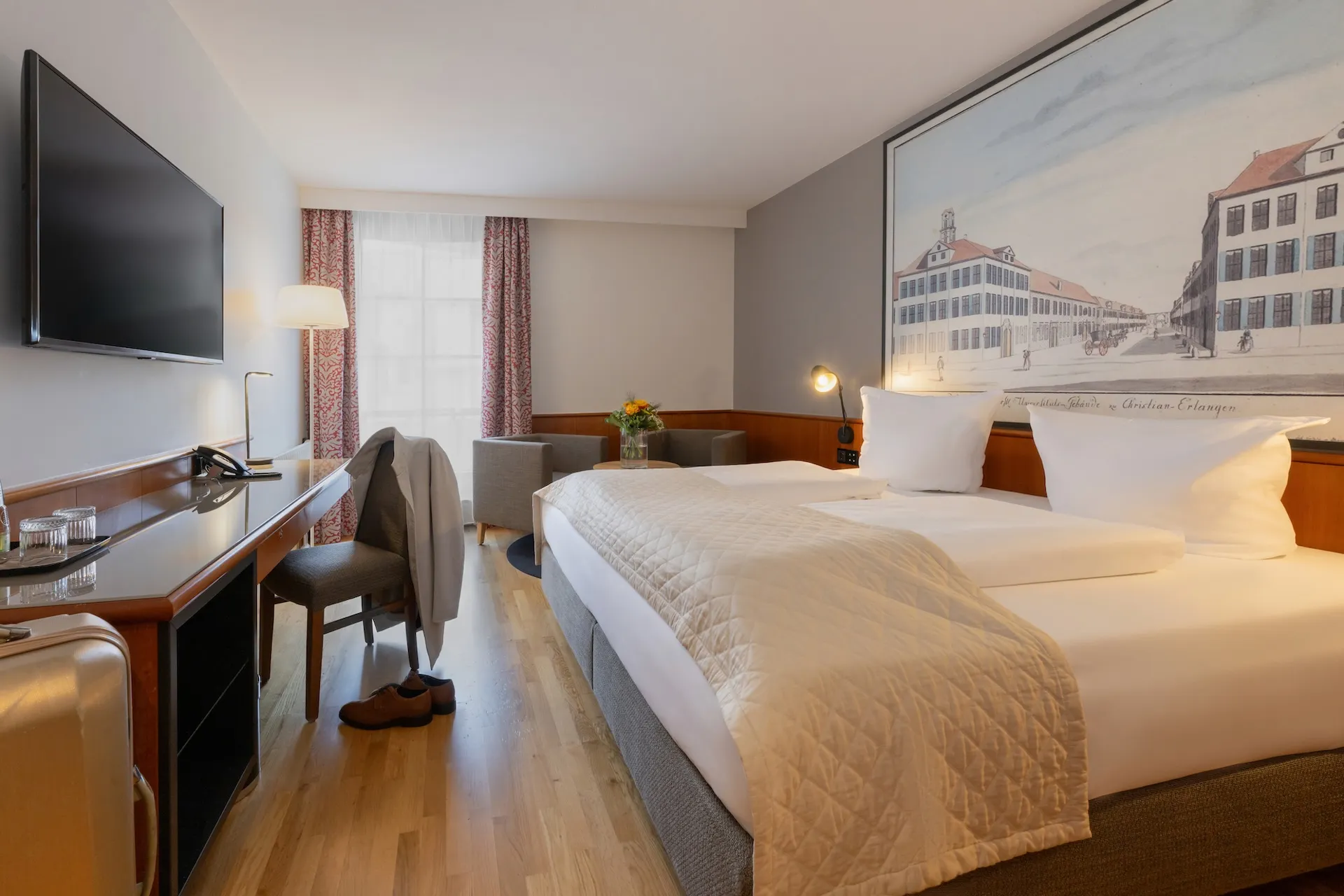 Hotelzimmer mit grossem Doppelbett und Wandbild, einladende Schlafzimmeratmosphäre