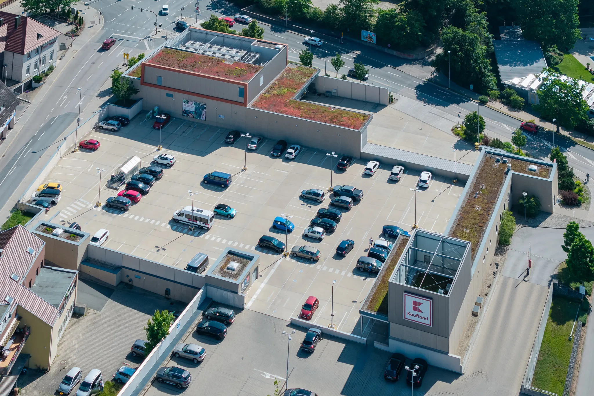 Luftaufnahme einer Kaufland-Filiale mit begrüntem Dach und Parkplatz