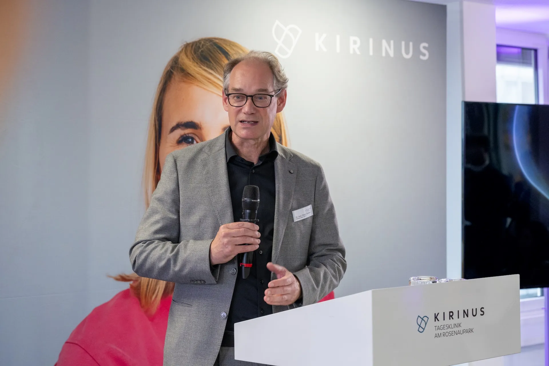 Redner mit Mikrofon bei der KIRINUS Eröffnung