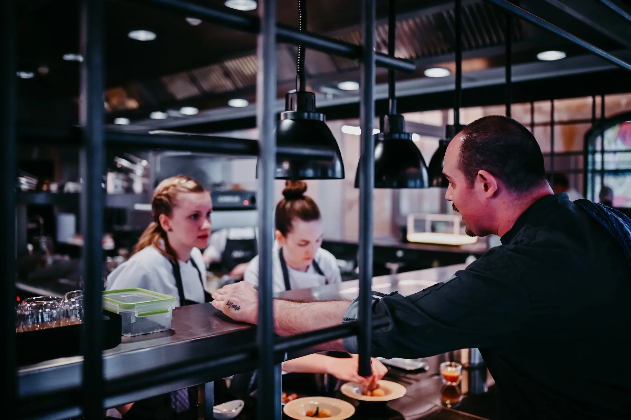 Küchenteam beim Anrichten an der Passierstation, authentische Gastronomie-Reportage.