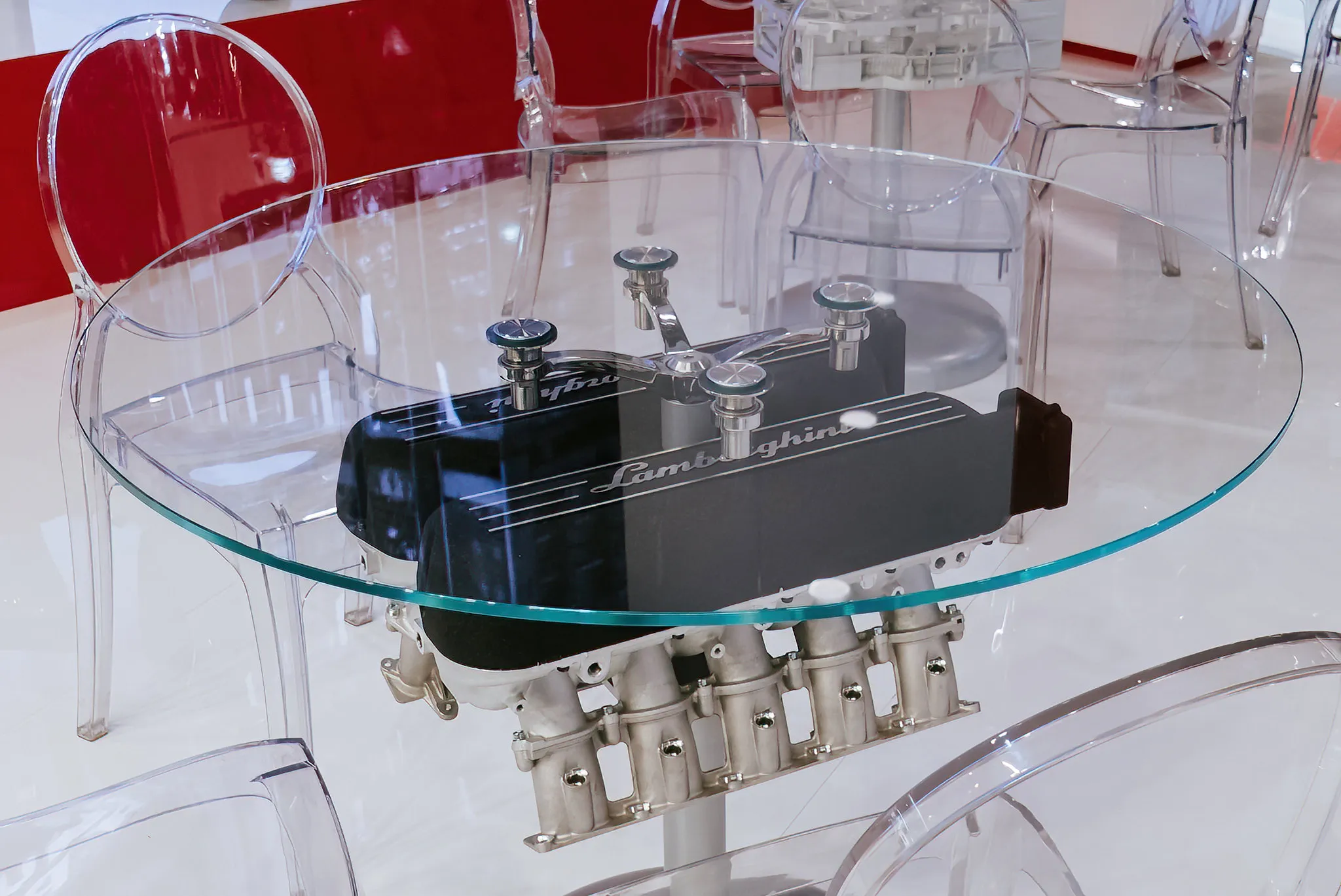 Lamborghini-Motor als Basis eines runden Glastisches, außergewöhnliches Designprodukt professionell inszeniert.