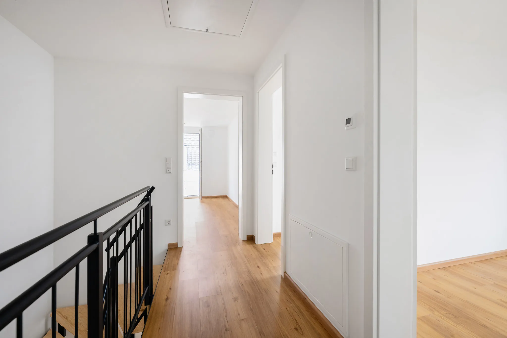 Maisonette-Treppenaufgang mit Holzboden und Galerie.