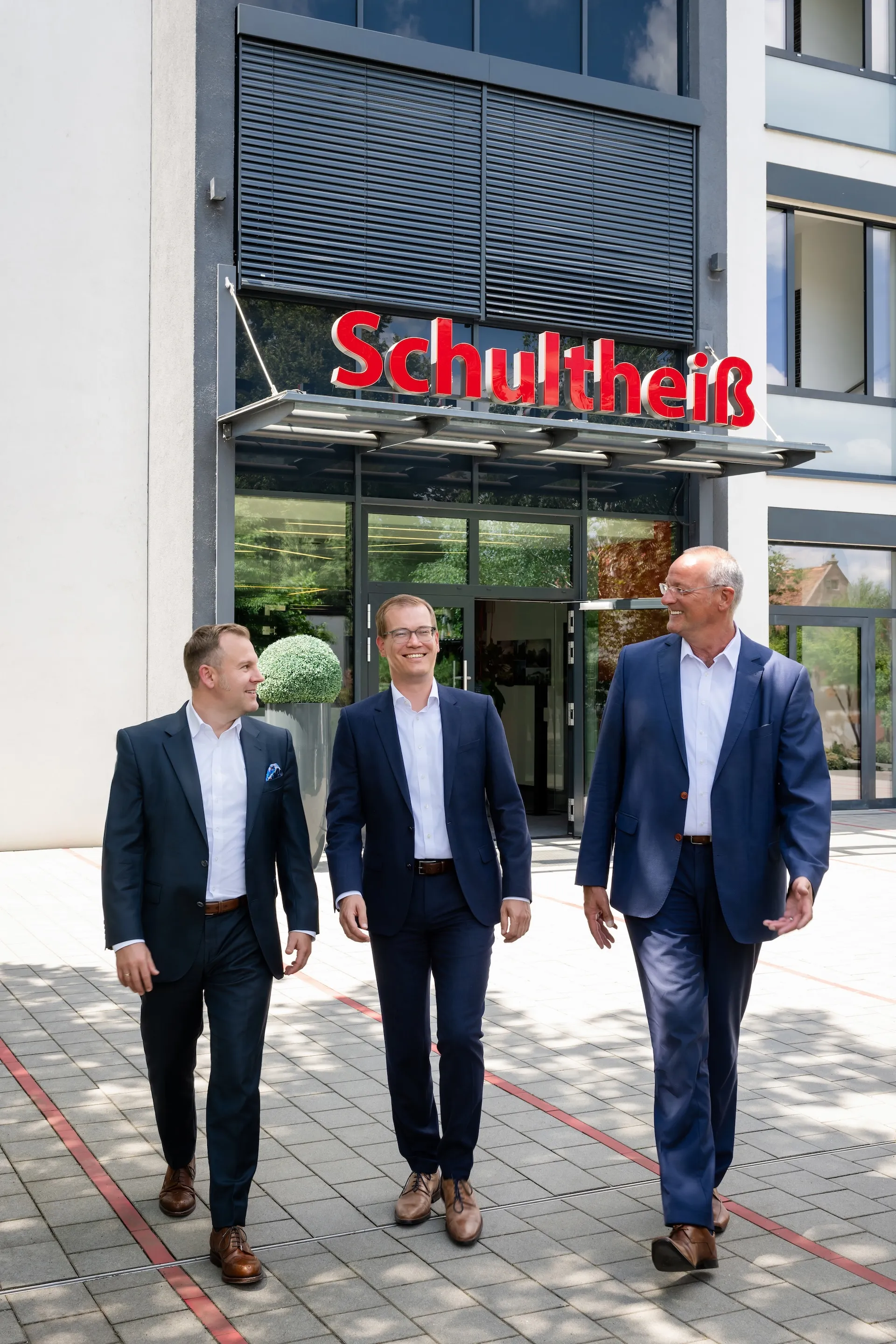Geschäftsführer vor neuem Firmensitz, Erfolg visuell inszeniert.