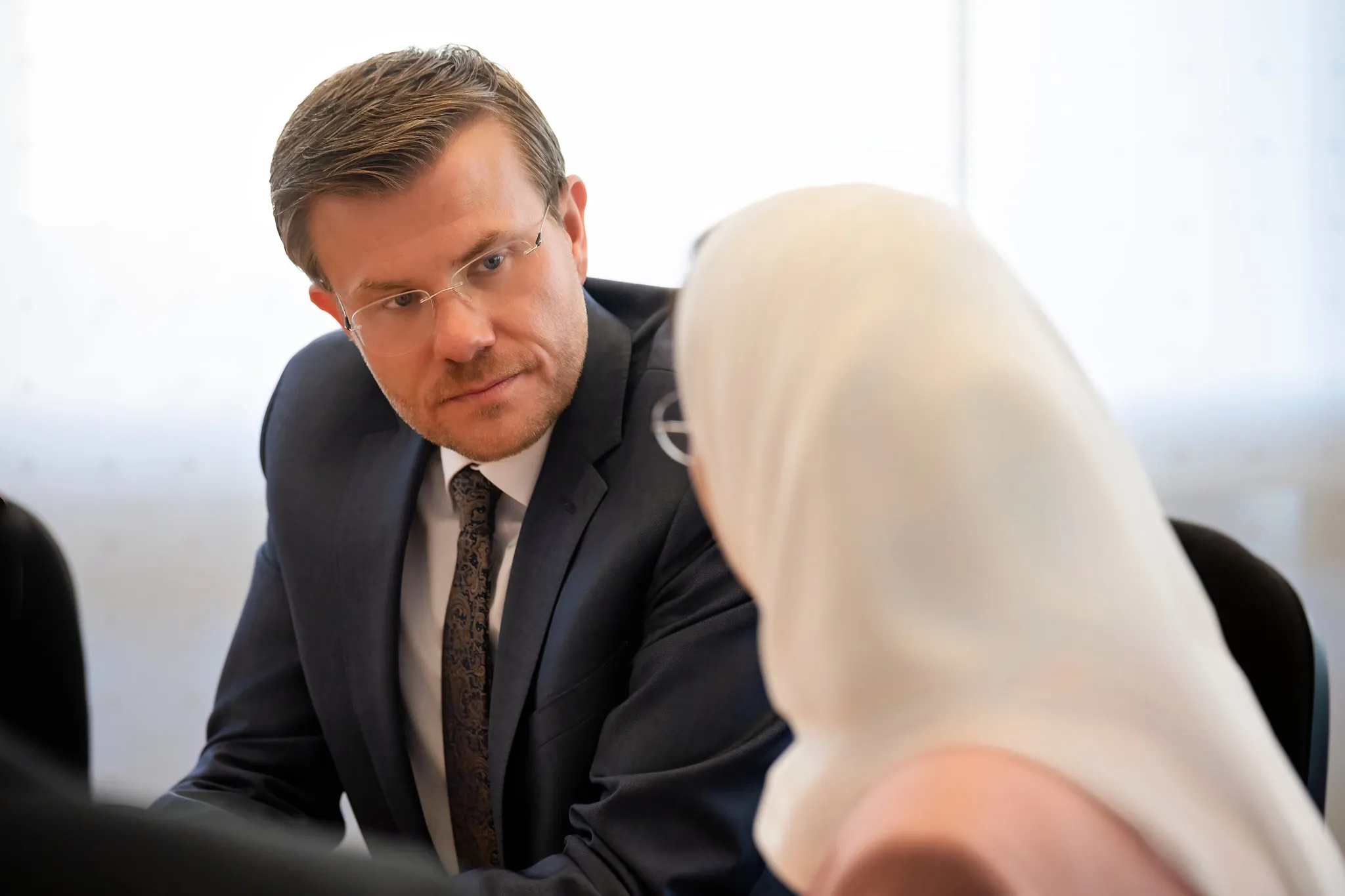 Mann im dunklen Anzug im Gespräch, konzentriertes Business-Portrait in Nahaufnahme