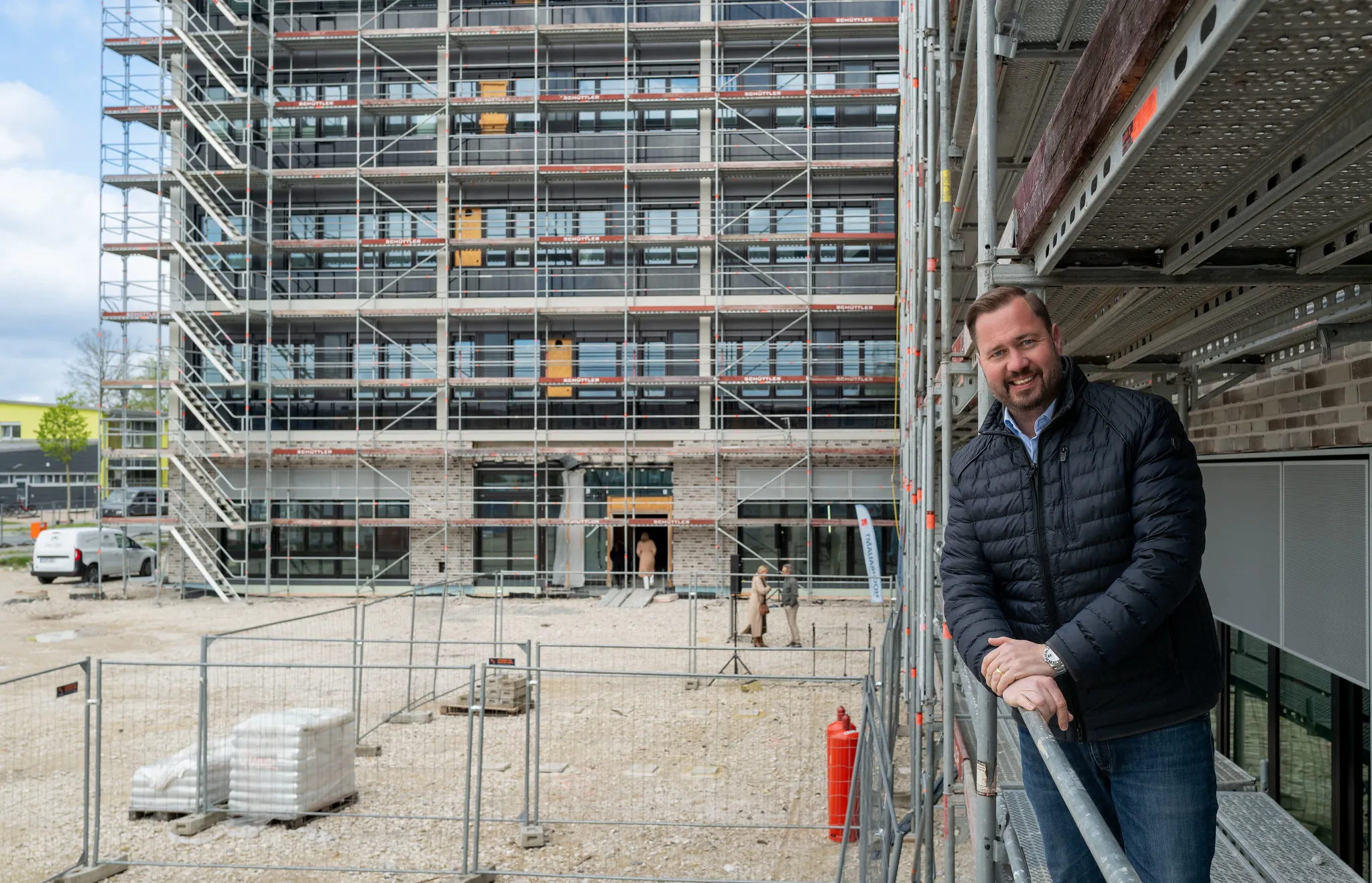 Mann lehnt am Gerüst beim Baufest vor dem Neubau