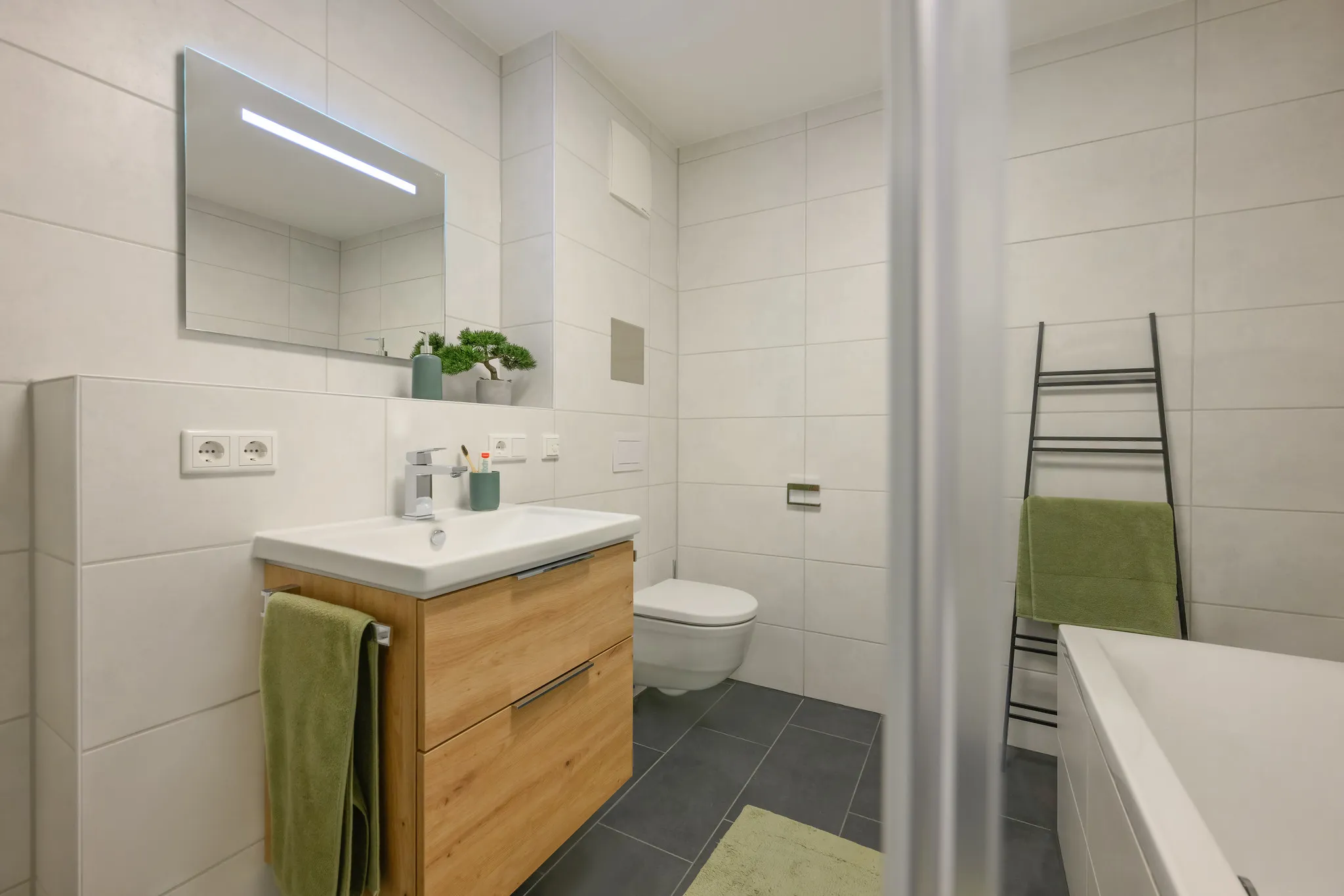 Modernes Badezimmer mit Holz-Waschtisch, Dusche und Wanne.