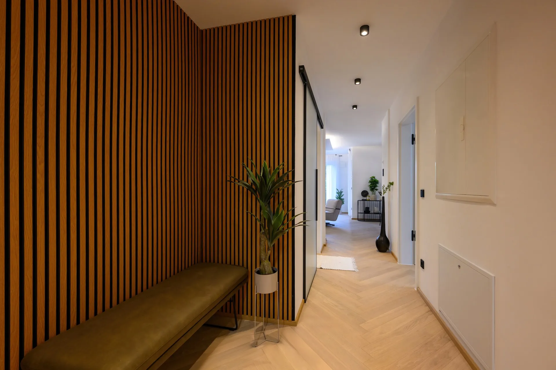 Wohnungsinterieur mit Holzlamellenwand, harmonisches Lichtspiel.