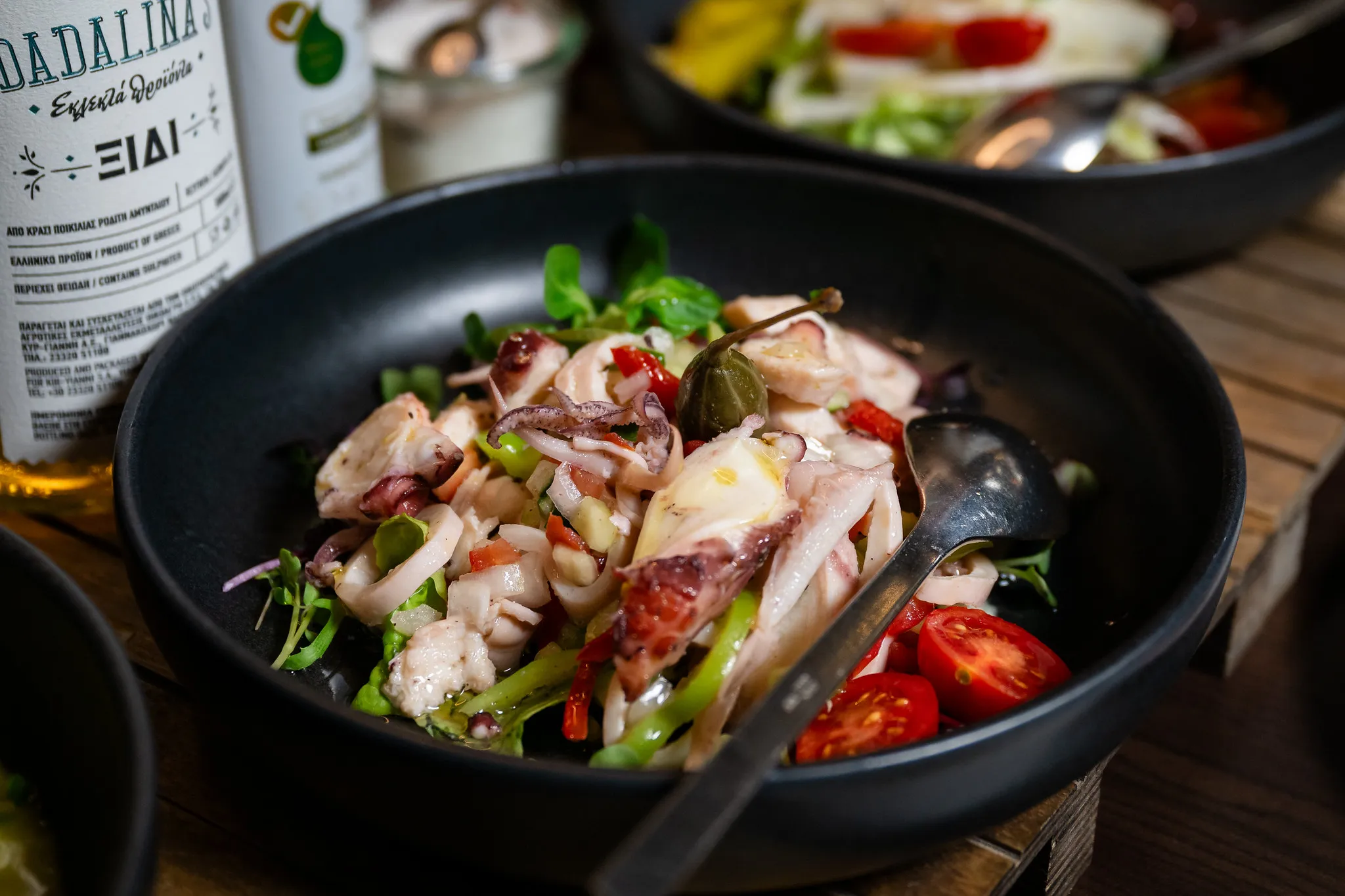 Oktopussalat mit Kapern, Tomaten und Weinessig, frische mediterrane Vorspeise.
