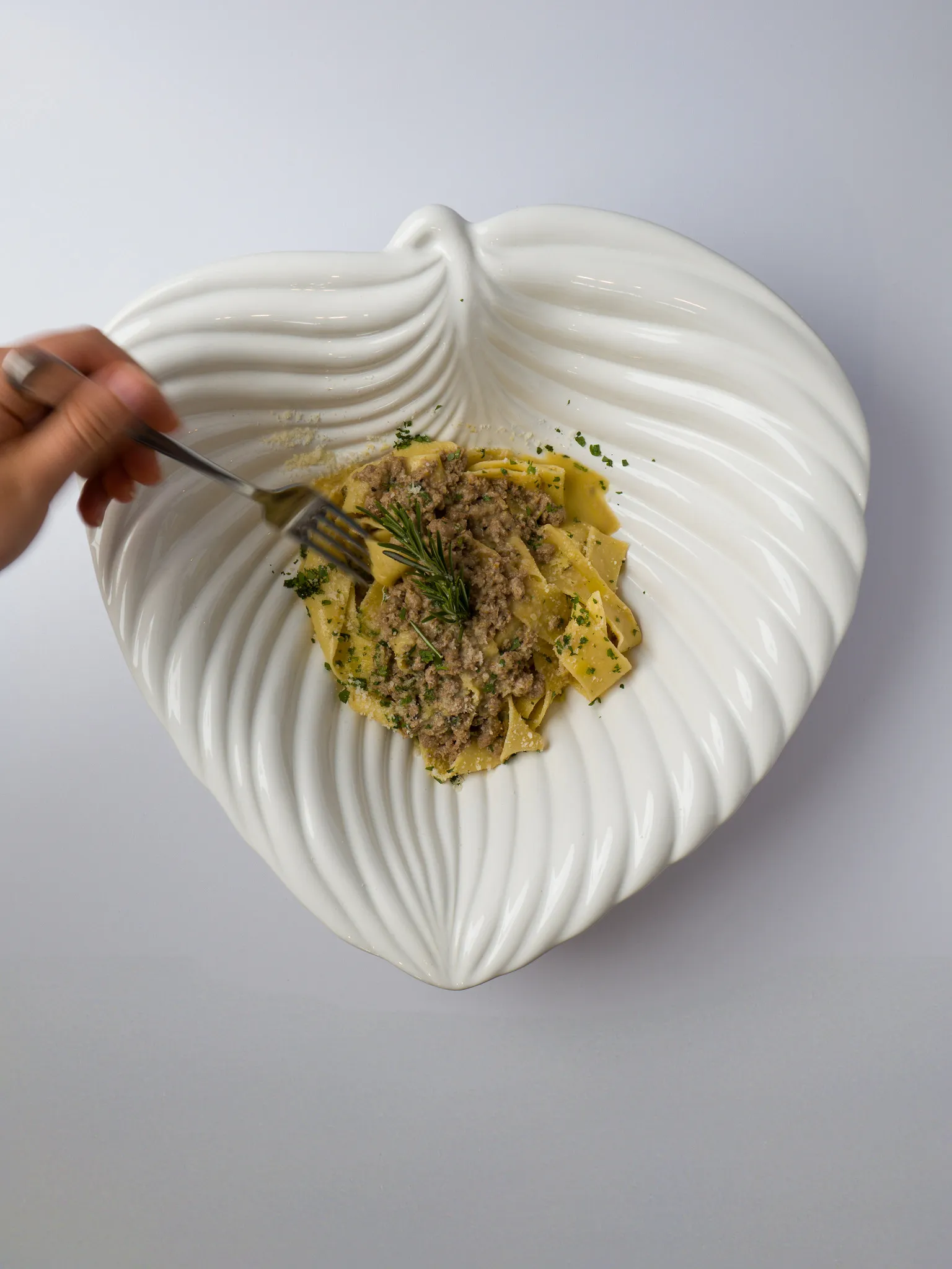 Pappardelle mit Fleischragout auf muschelförmigem Designerteller, Pasta-Fotografie.