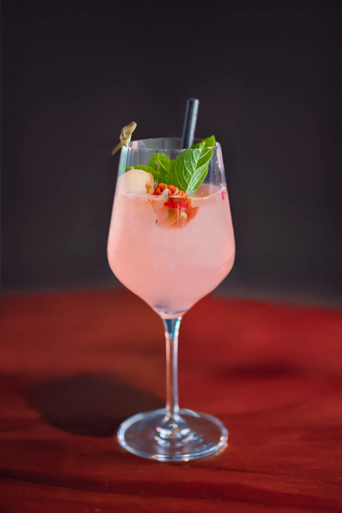Rosa Cocktail im Weinglas mit frischer Minze, Getränke-Fotografie für die Gastronomie.
