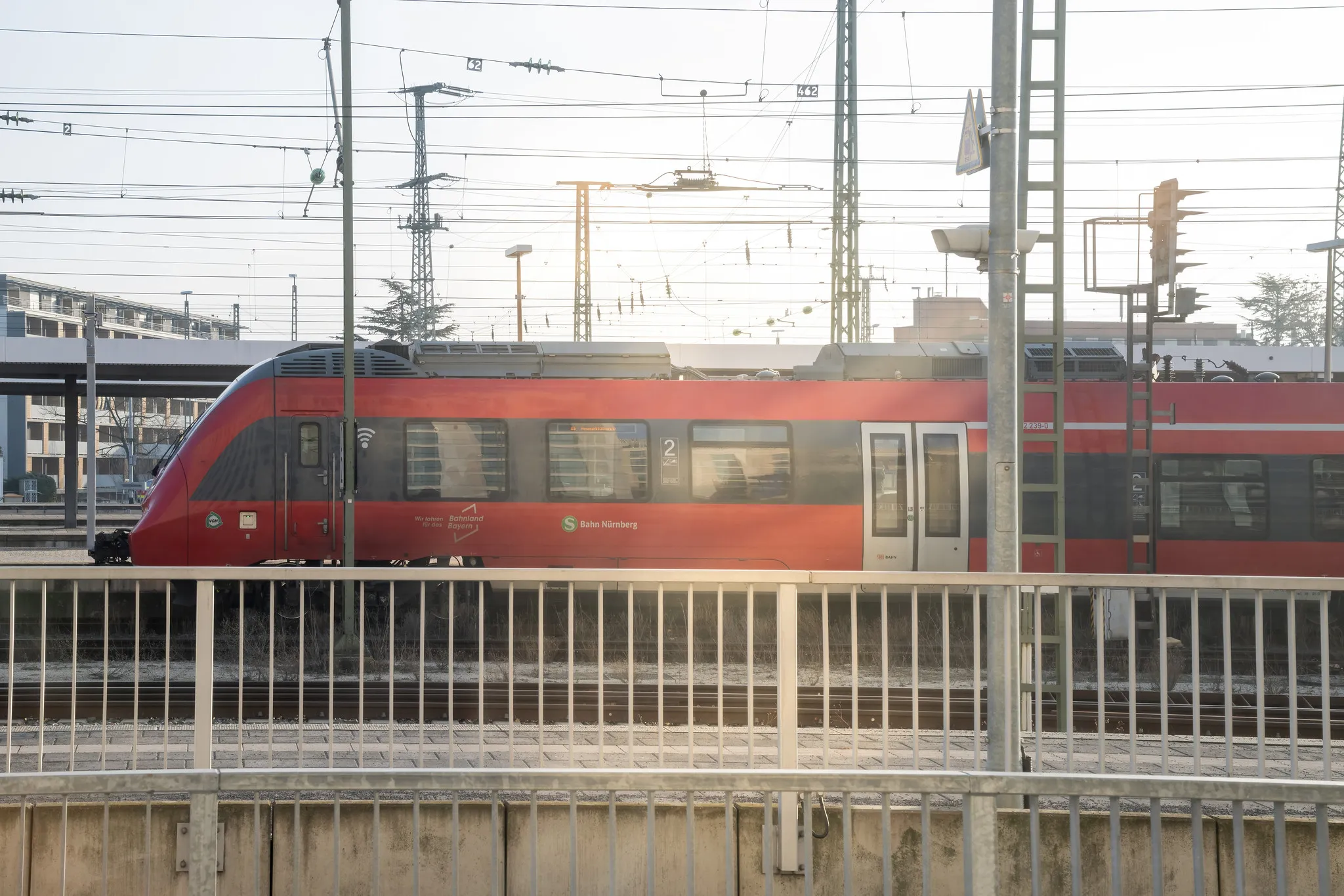 Roter Zug der S-Bahn Nürnberg am Bahnsteig im Gegenlicht.