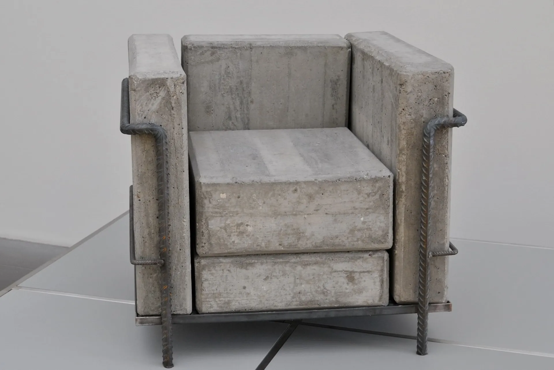 Sessel aus Beton und Stahl, architektonisch inszenierte Materialästhetik.