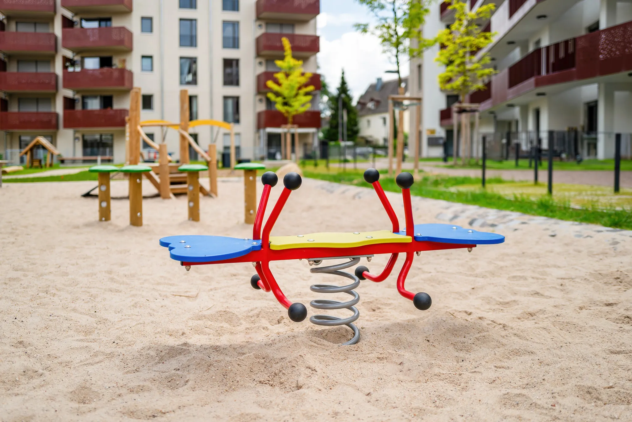 Bunte Federwippe auf einem Spielplatz im Wohnquartier.