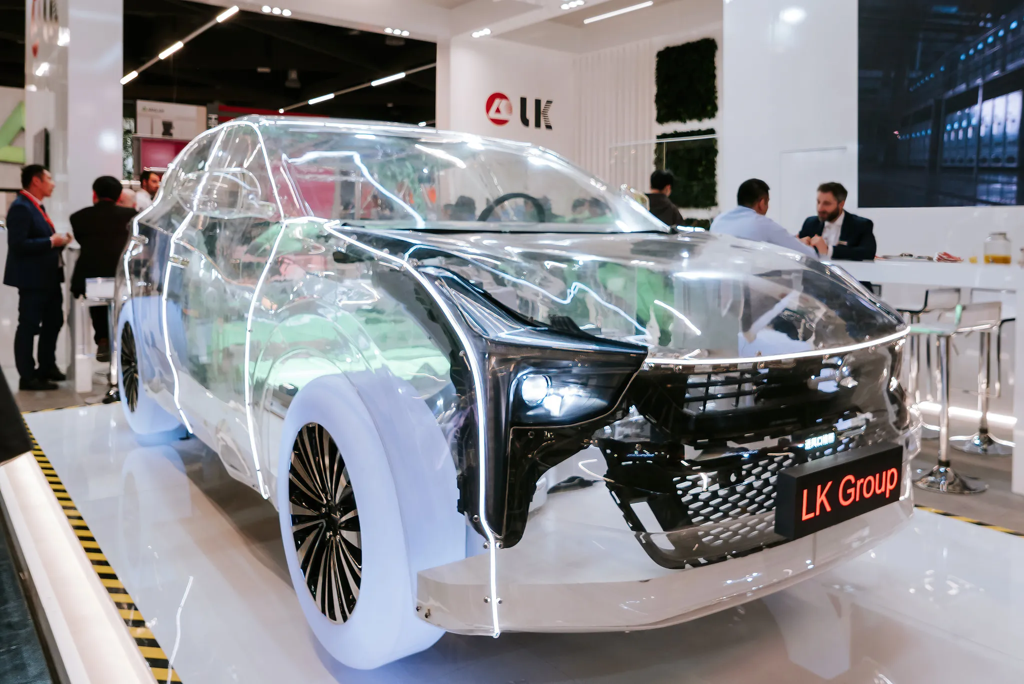 Transparentes Elektroauto-Modell der LK Group auf Messestand, spektakuläre Produktpräsentation.